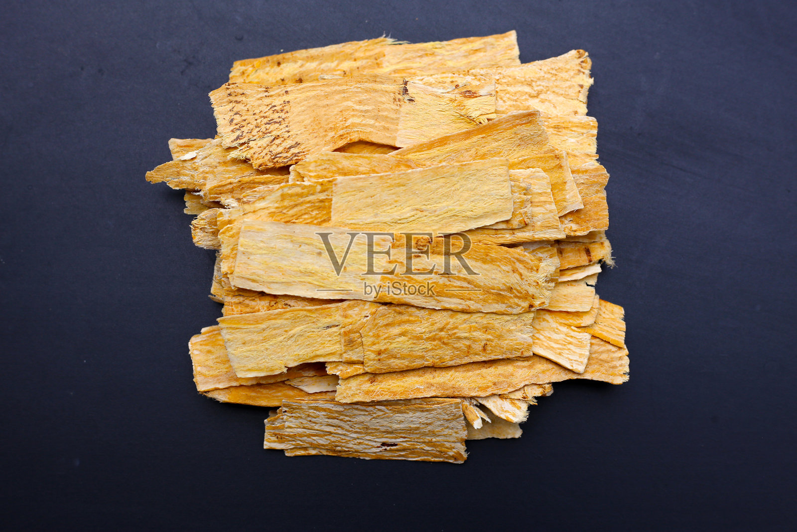 用于传统中药的干黄芪根切片。照片摄影图片