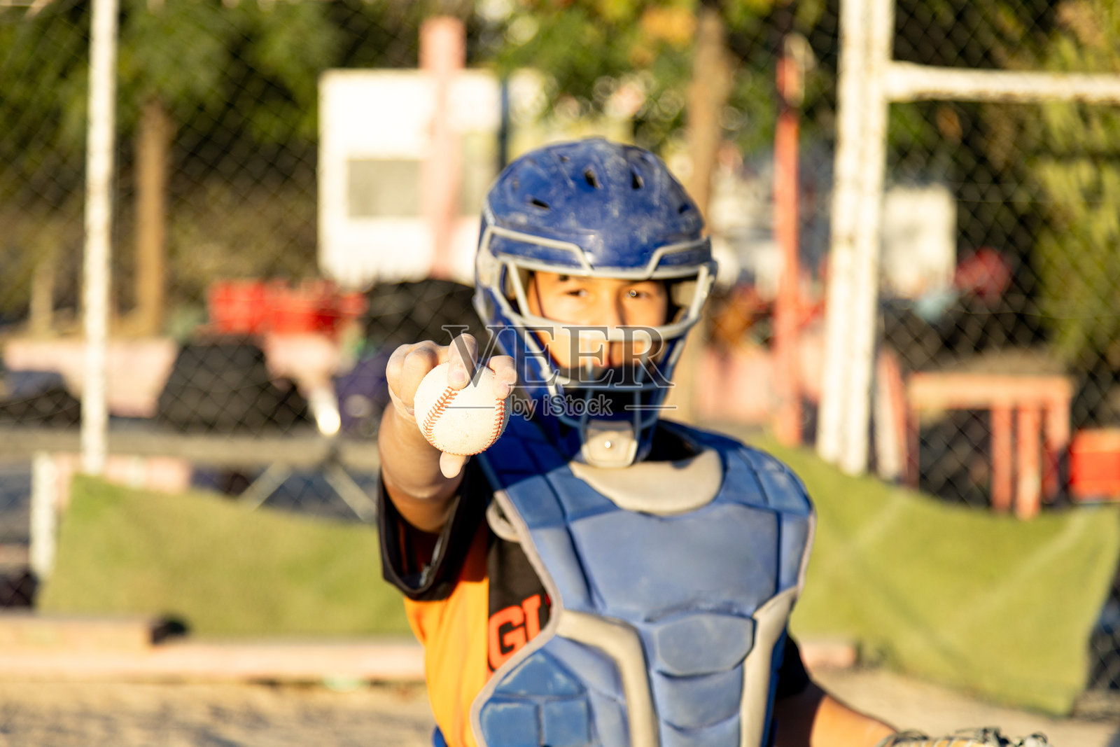 年轻的棒球捕手在球场上自豪地拿着球照片摄影图片