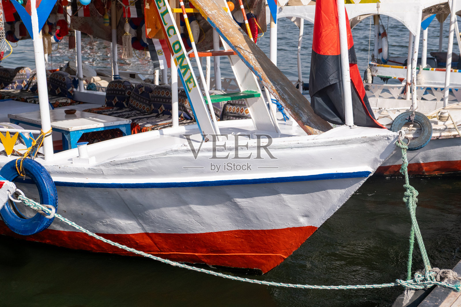 埃及卢克索尼罗河上停泊的色彩缤纷的传统费卢卡帆船照片摄影图片