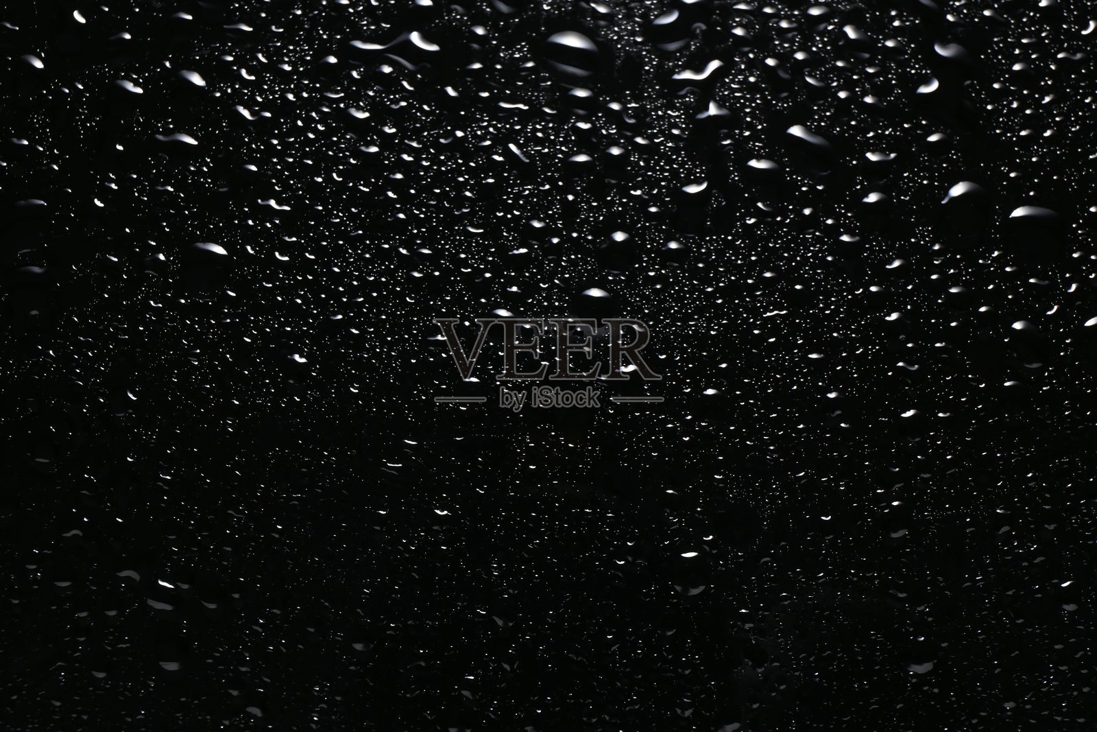 黑色玻璃表面的水滴，俯视角度照片摄影图片