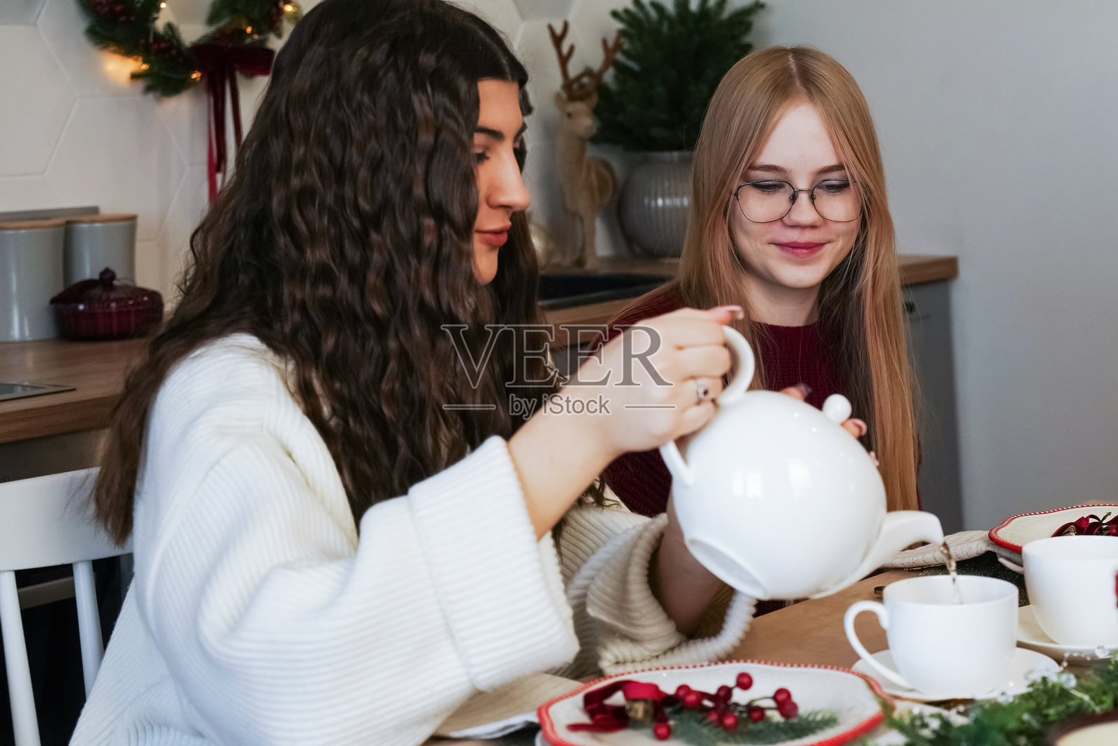 朋友们在舒适的冬季聚会中在家一起享受茶时光照片摄影图片