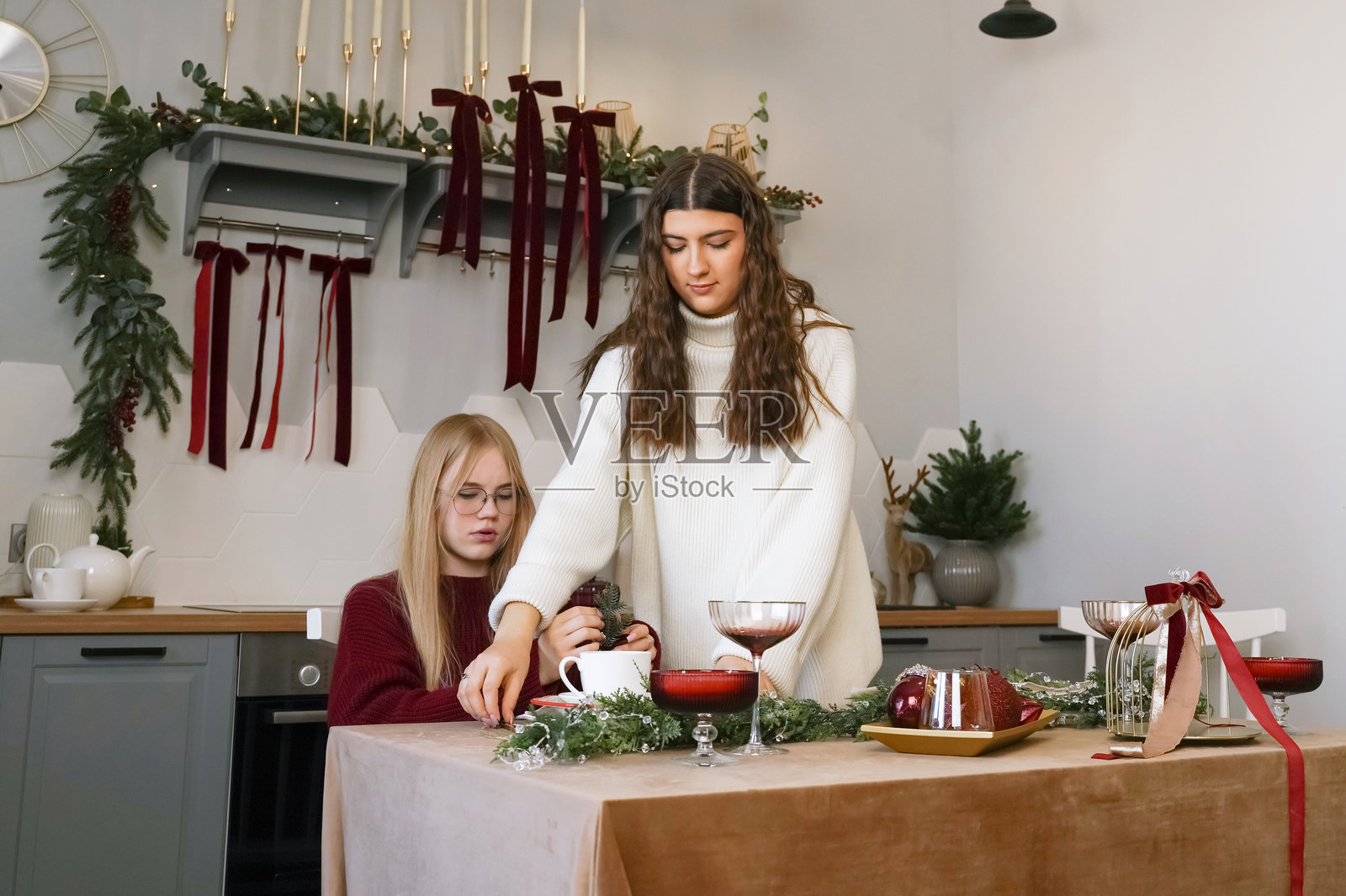 朋友们在温馨的厨房里装饰着，准备着节日聚会照片摄影图片