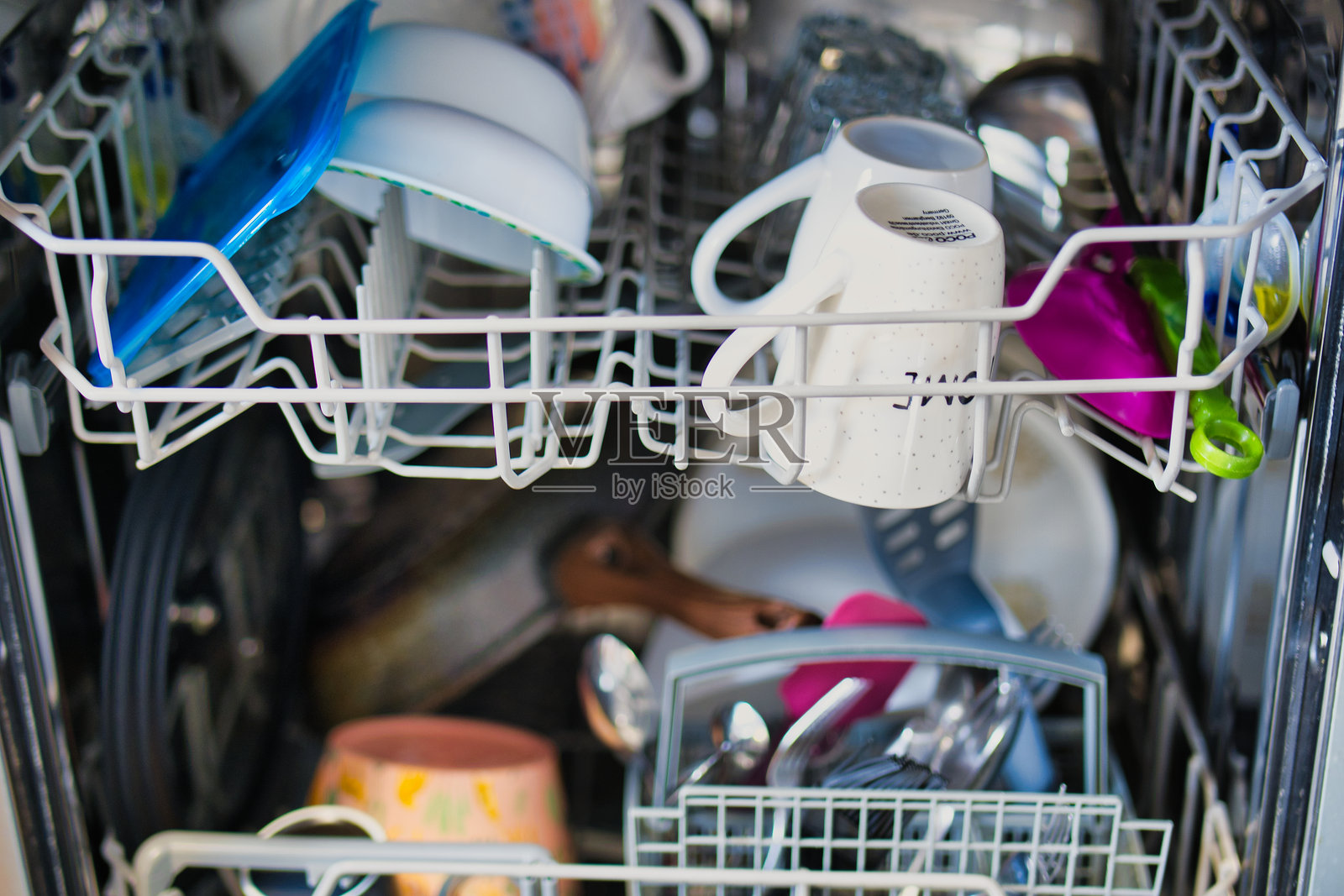 洗碗机内部视图，装有各种餐具、器皿和厨具，准备进行清洁循环照片摄影图片