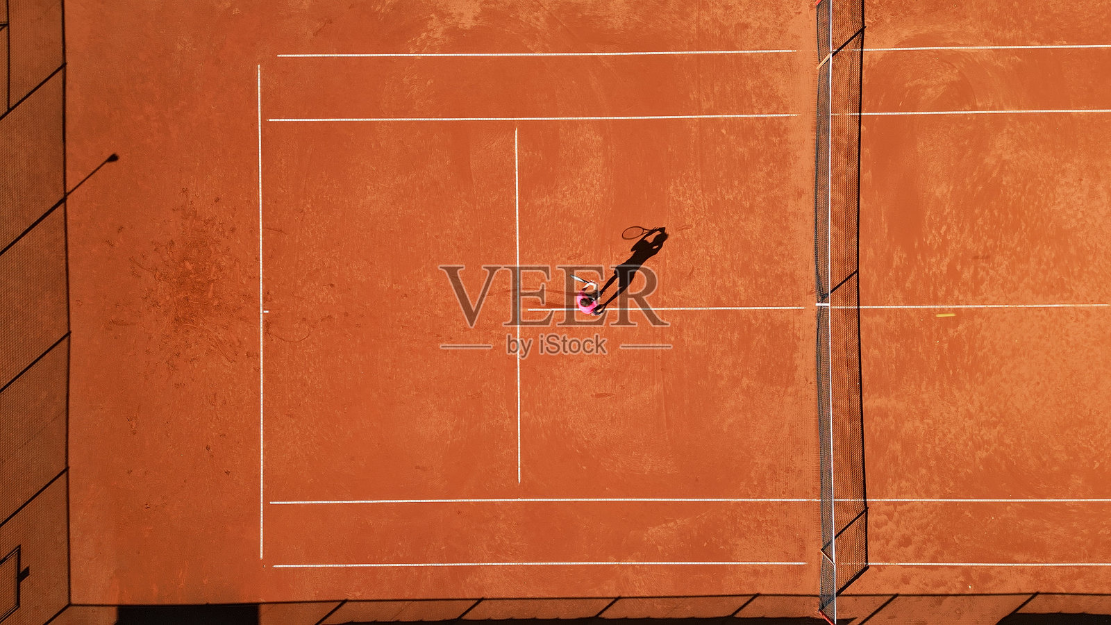 网球运动员在红土球场上练习照片摄影图片