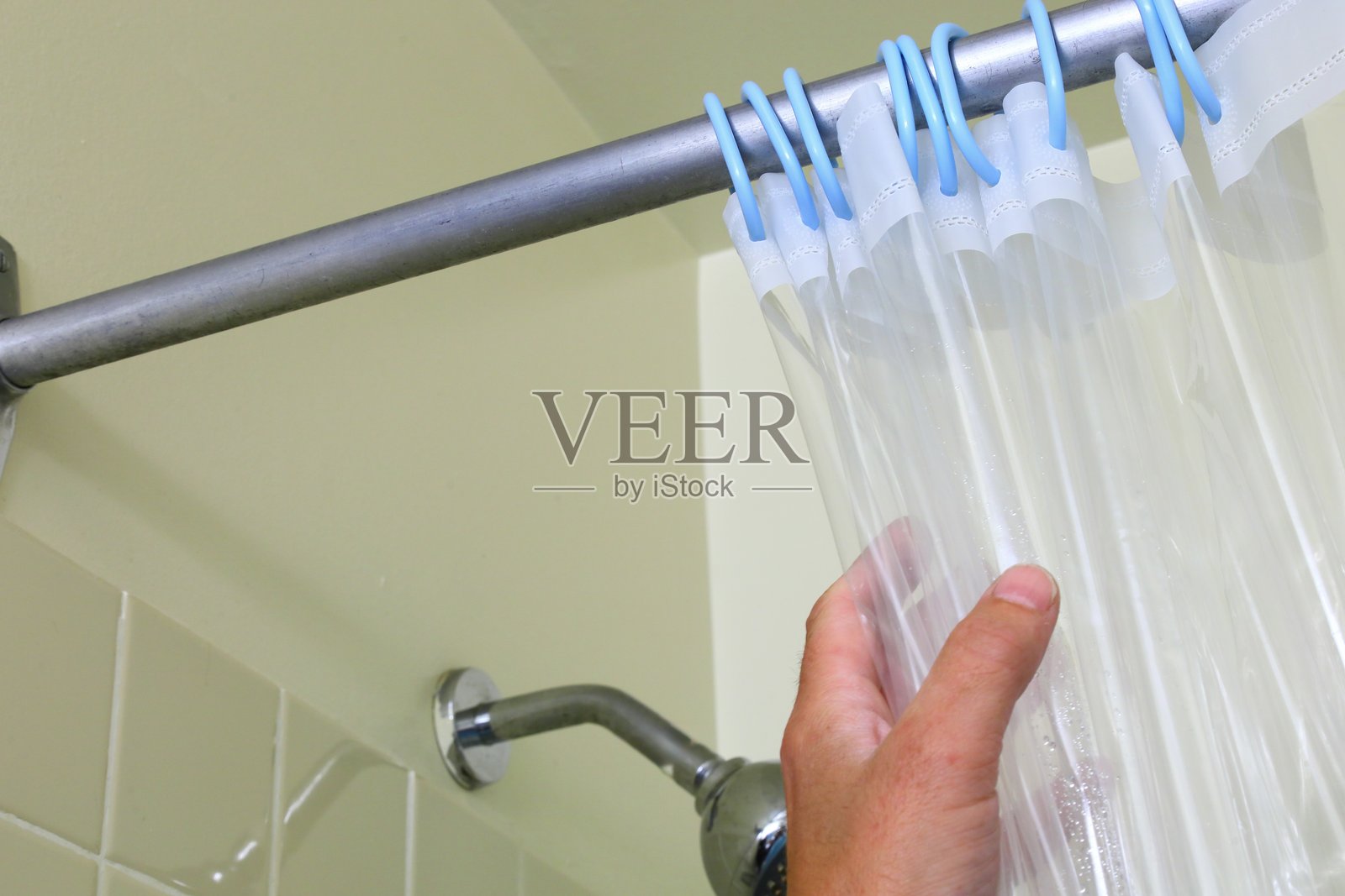 手正在调整透明的浴帘挂圈照片摄影图片