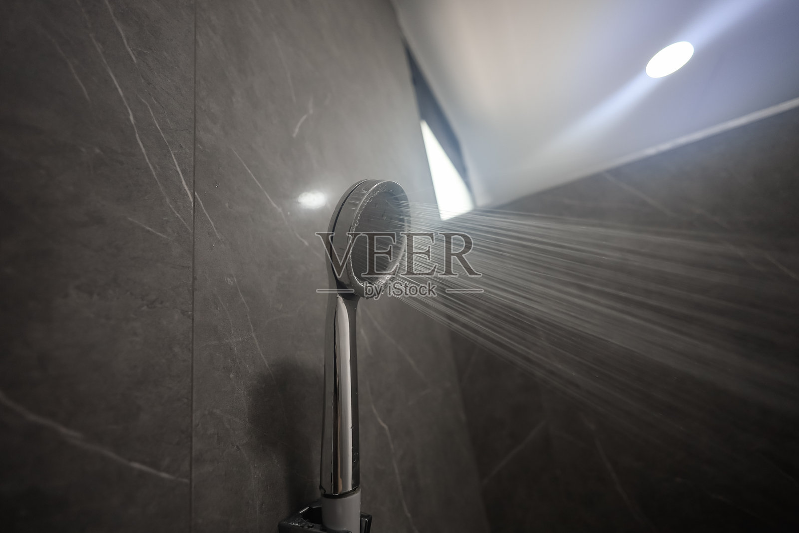 浴室里，温水正从淋浴喷头中流出照片摄影图片
