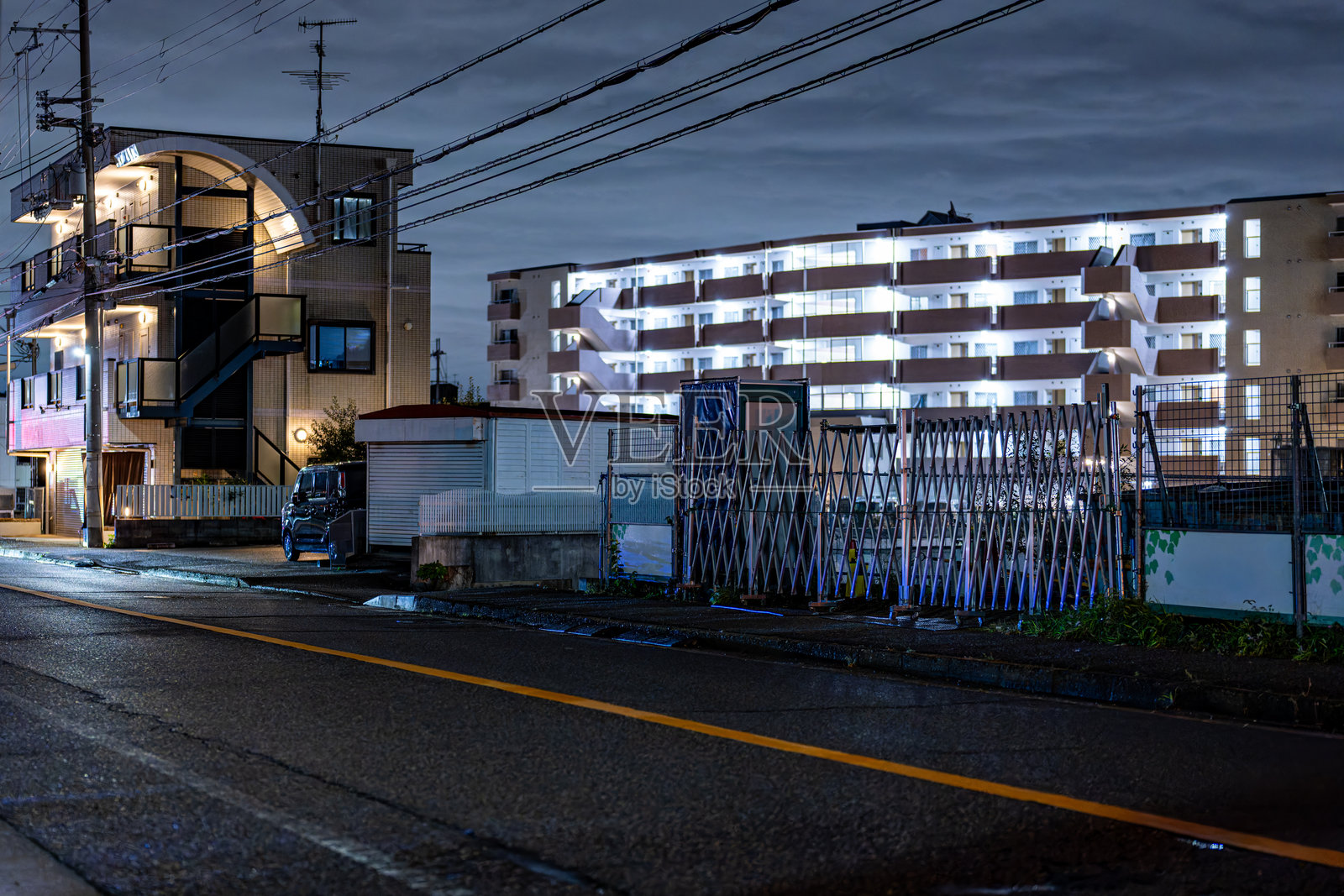 夜晚宁静的住宅小巷 — 雨后湿漉漉的街道映照着倒影照片摄影图片