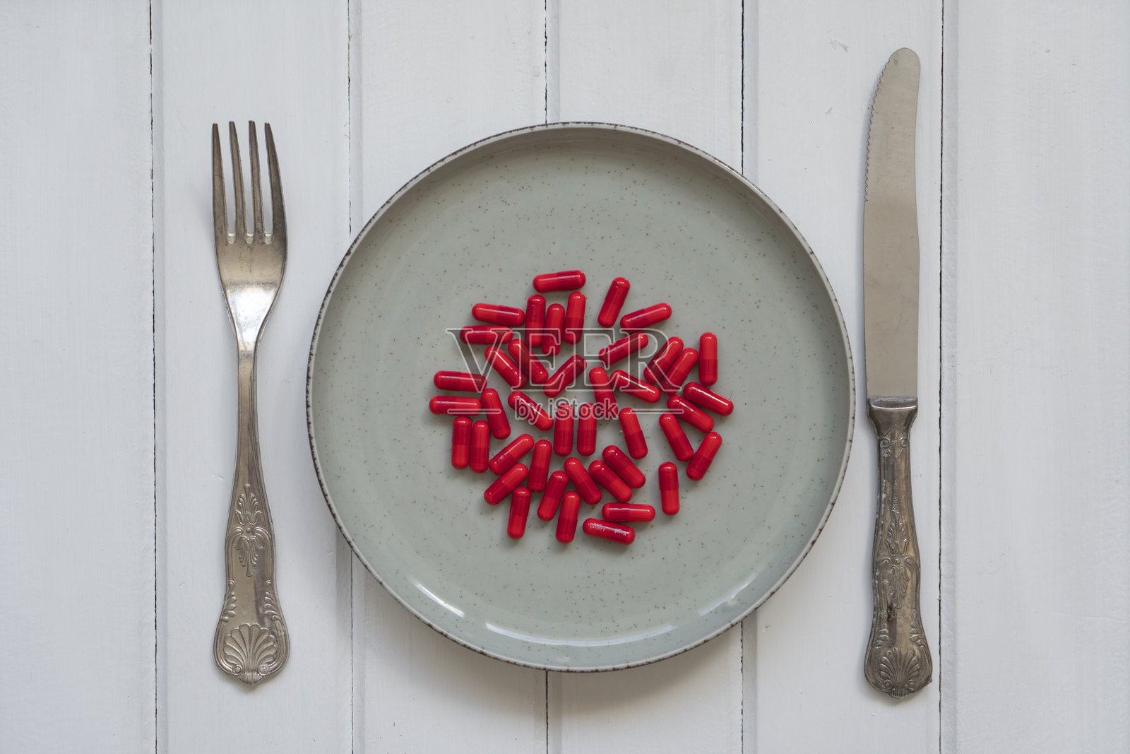 医疗保健，主食，木质背景上的盘子里的红色药丸照片摄影图片