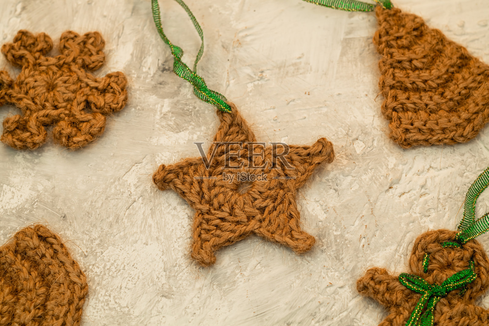 许多可爱的钩针编织圣诞玩具，由环保黄麻制成，挂在圣诞树上。圣诞和新年装饰。照片摄影图片