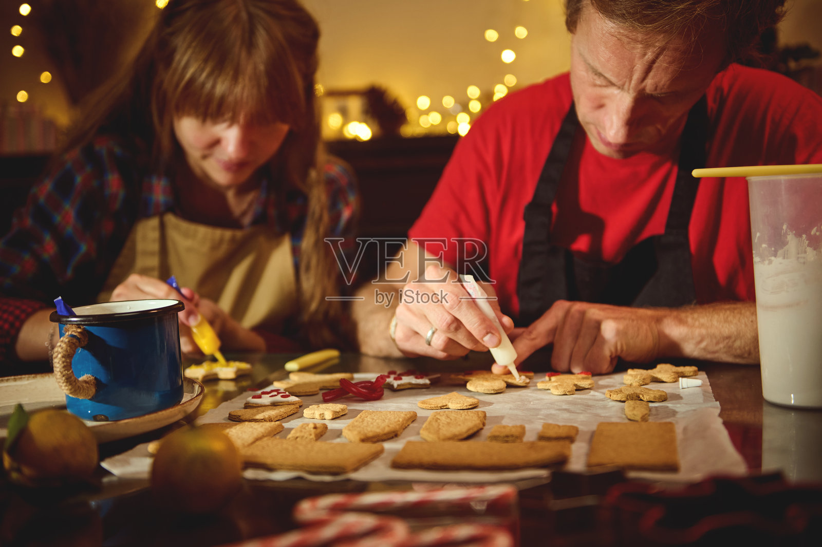家人和朋友们在温馨的节日厨房里，伴着温暖的灯光一起烘焙饼干照片摄影图片