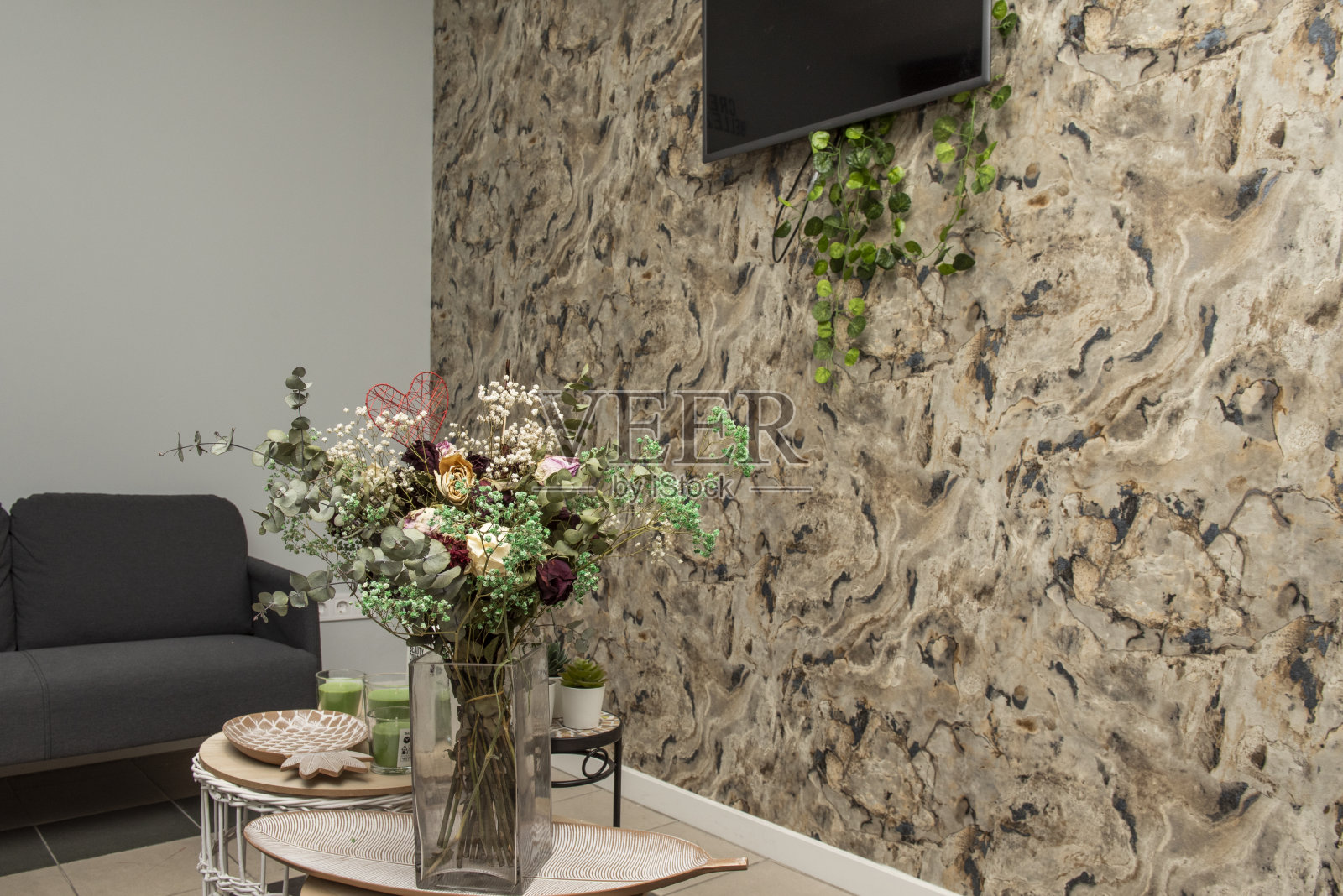 一个装满装饰性干花的玻璃花瓶放在陶瓷托盘上照片摄影图片