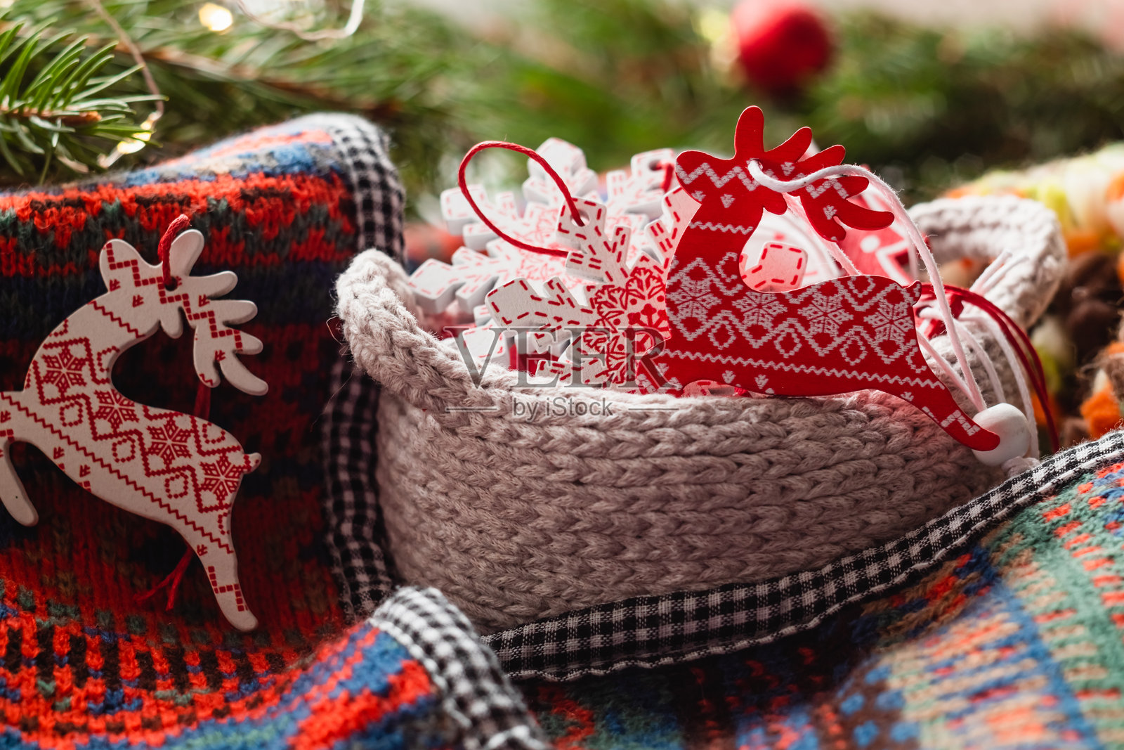 针织篮子里的圣诞木制玩具，背景虚化。圣诞木鹿。照片摄影图片