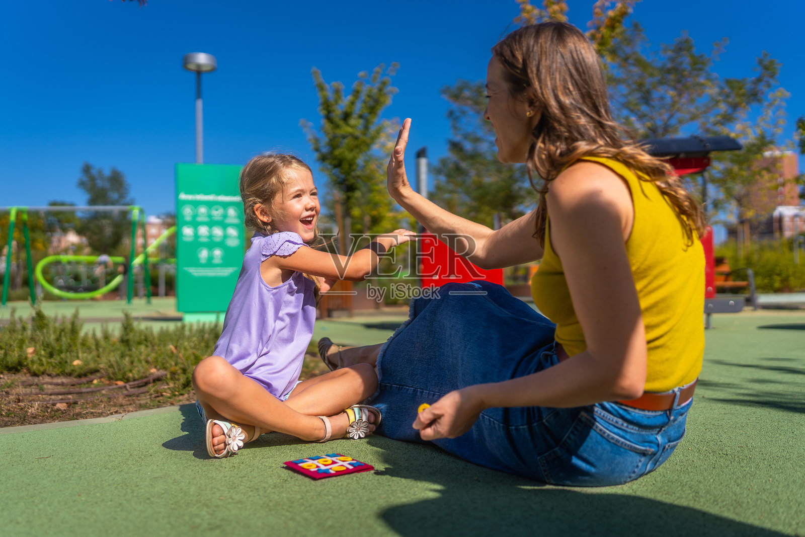 母女俩在游乐场击掌玩耍照片摄影图片