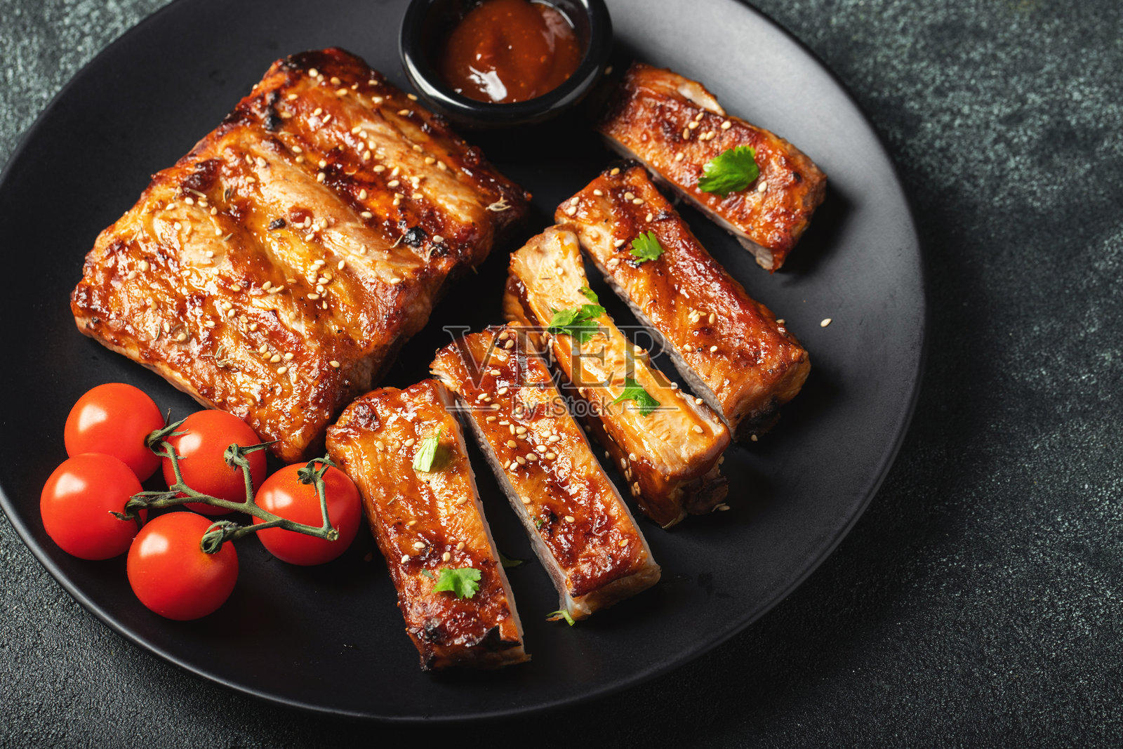 夏日烧烤的烤猪肋排，装在盘子里，配有酱汁，俯视角度，可供复制。照片摄影图片