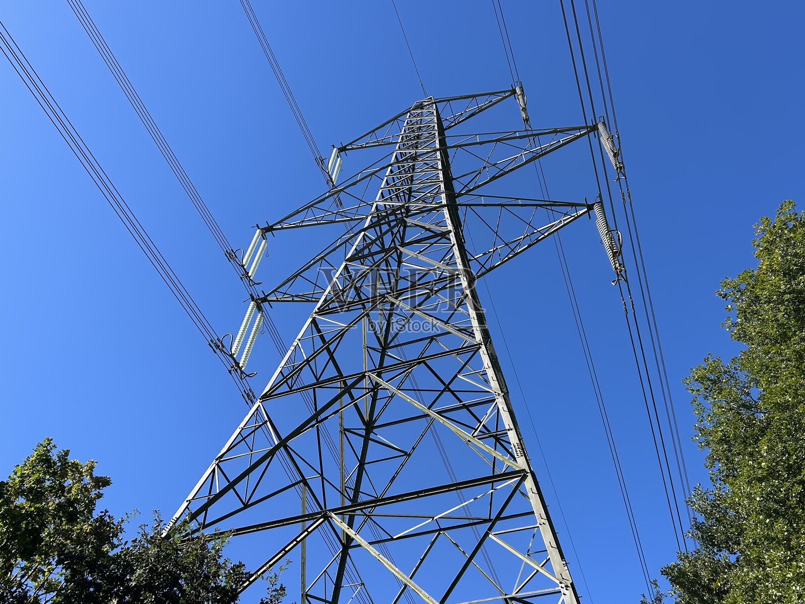 高压输电塔与电力线，背景是晴朗的蓝天照片摄影图片