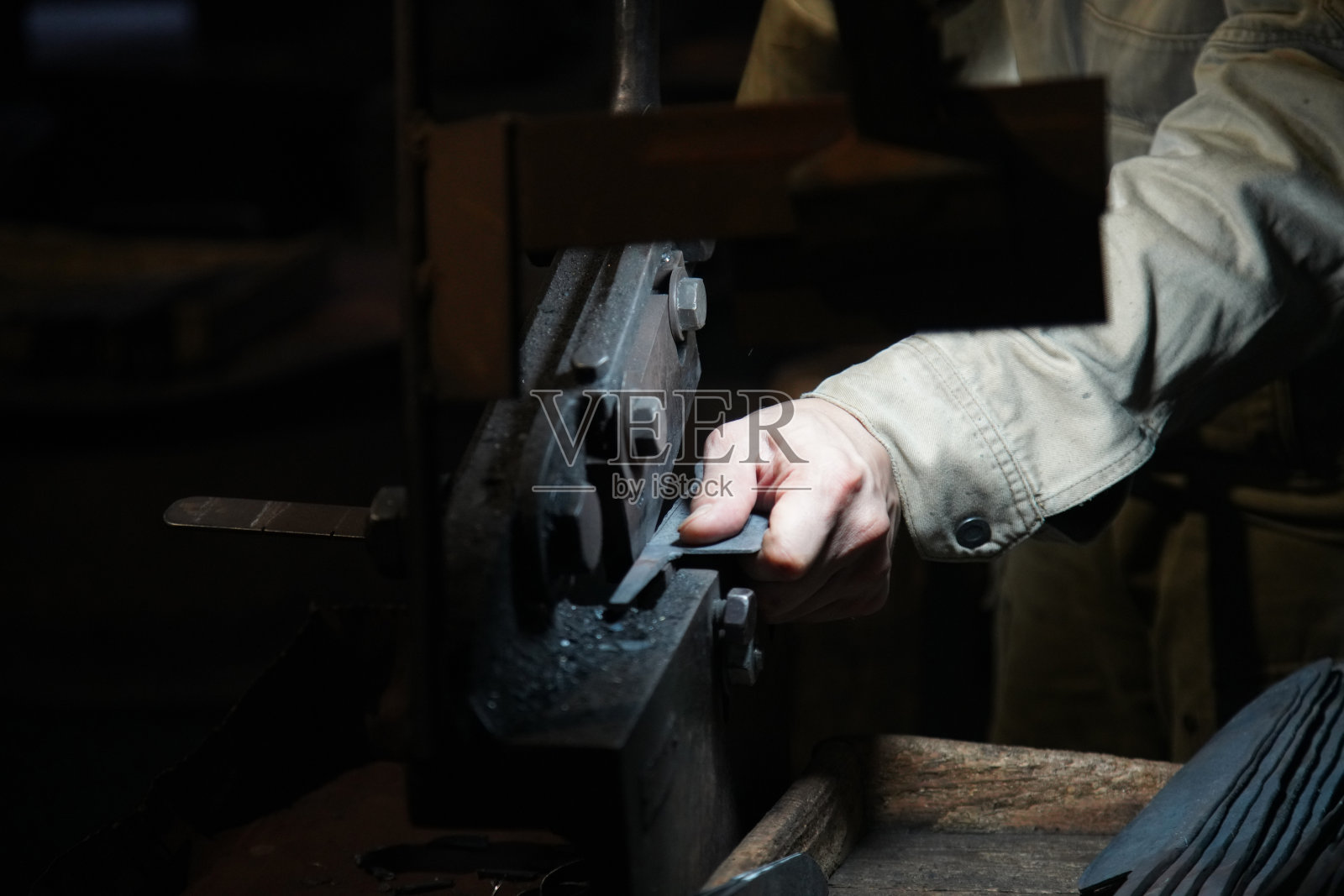 一位工匠用手剪将材料剪成刀的形状照片摄影图片