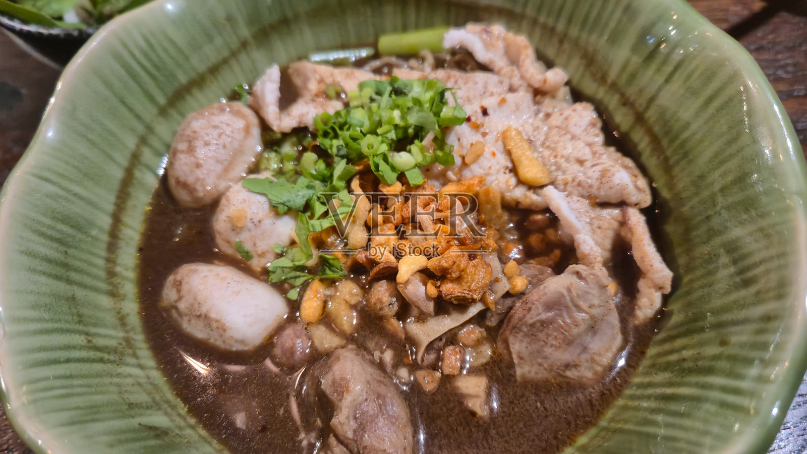 绿碗里的泰式船面，配有猪肉丸和香草照片摄影图片