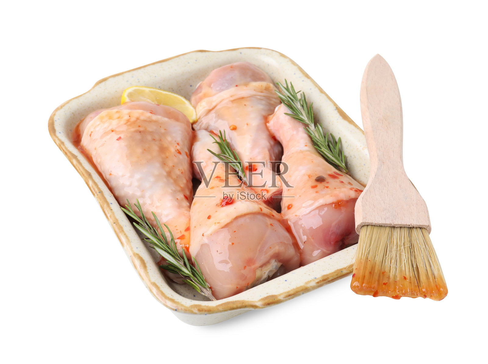 生的迷迭香、柠檬腌制鸡腿，配有刷子，孤立在白色背景上照片摄影图片