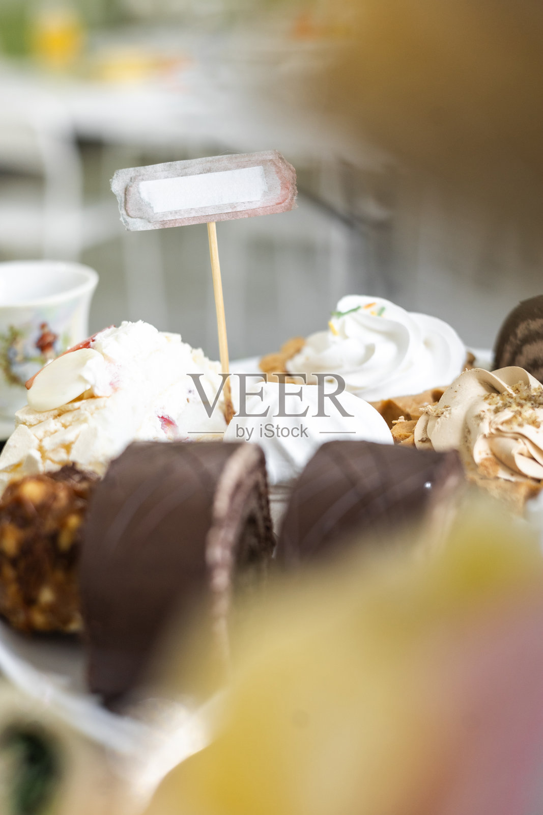 明亮灯光下桌上摆放着各式各样的甜点和糕点，附有空白标签照片摄影图片