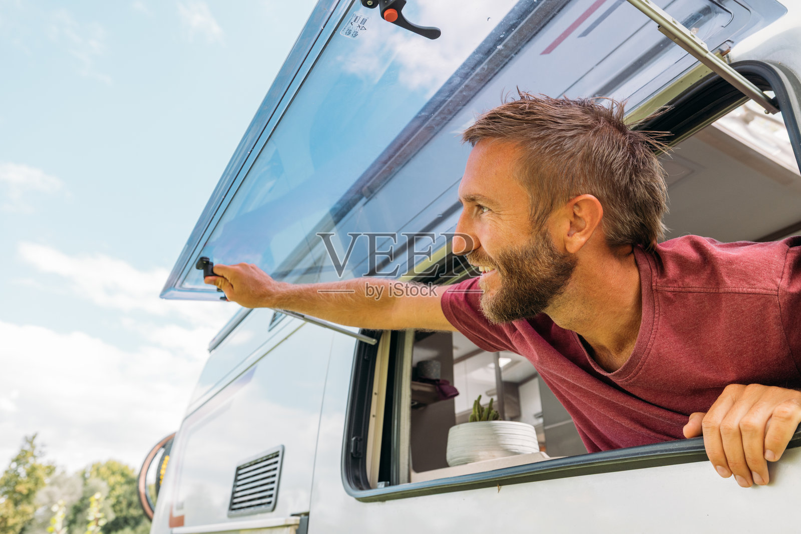 男人在户外打开露营车车窗照片摄影图片