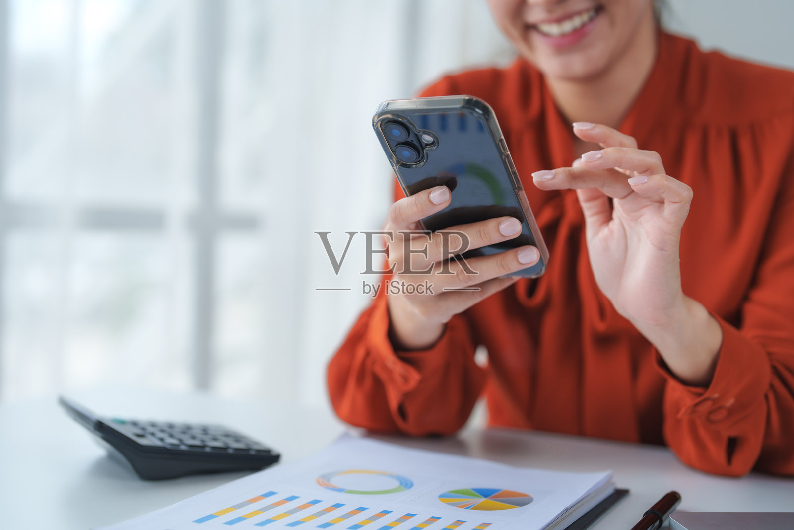 女商人在办公室里微笑着使用智能手机照片摄影图片