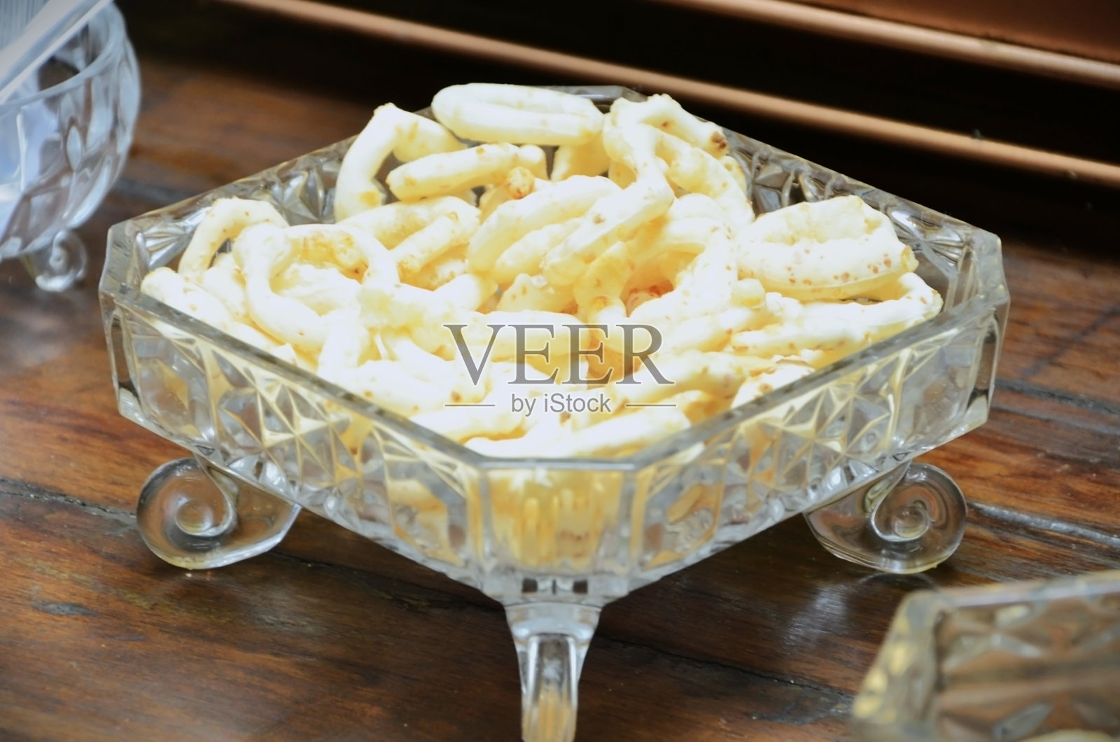 一个带底座的华丽玻璃碗，里面装满了木薯饼干照片摄影图片