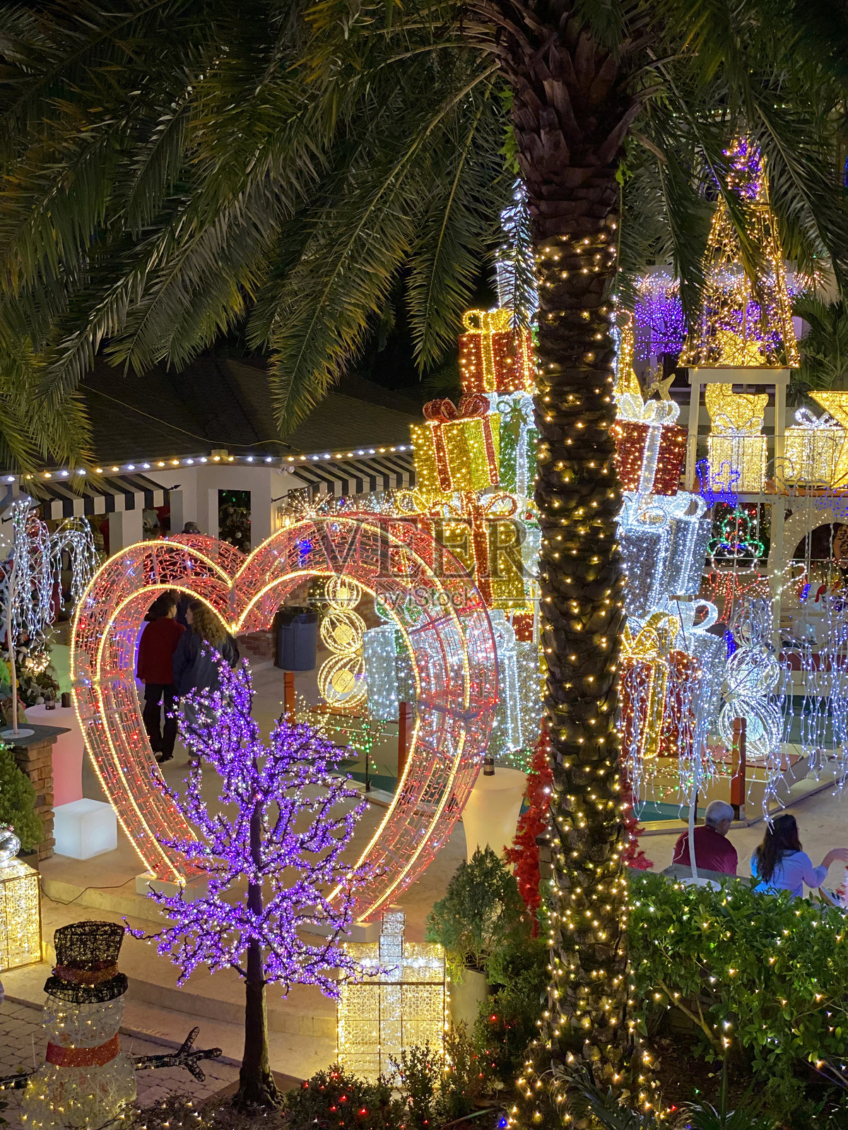 心形灯饰搭配圣诞礼物和棕榈树照片摄影图片