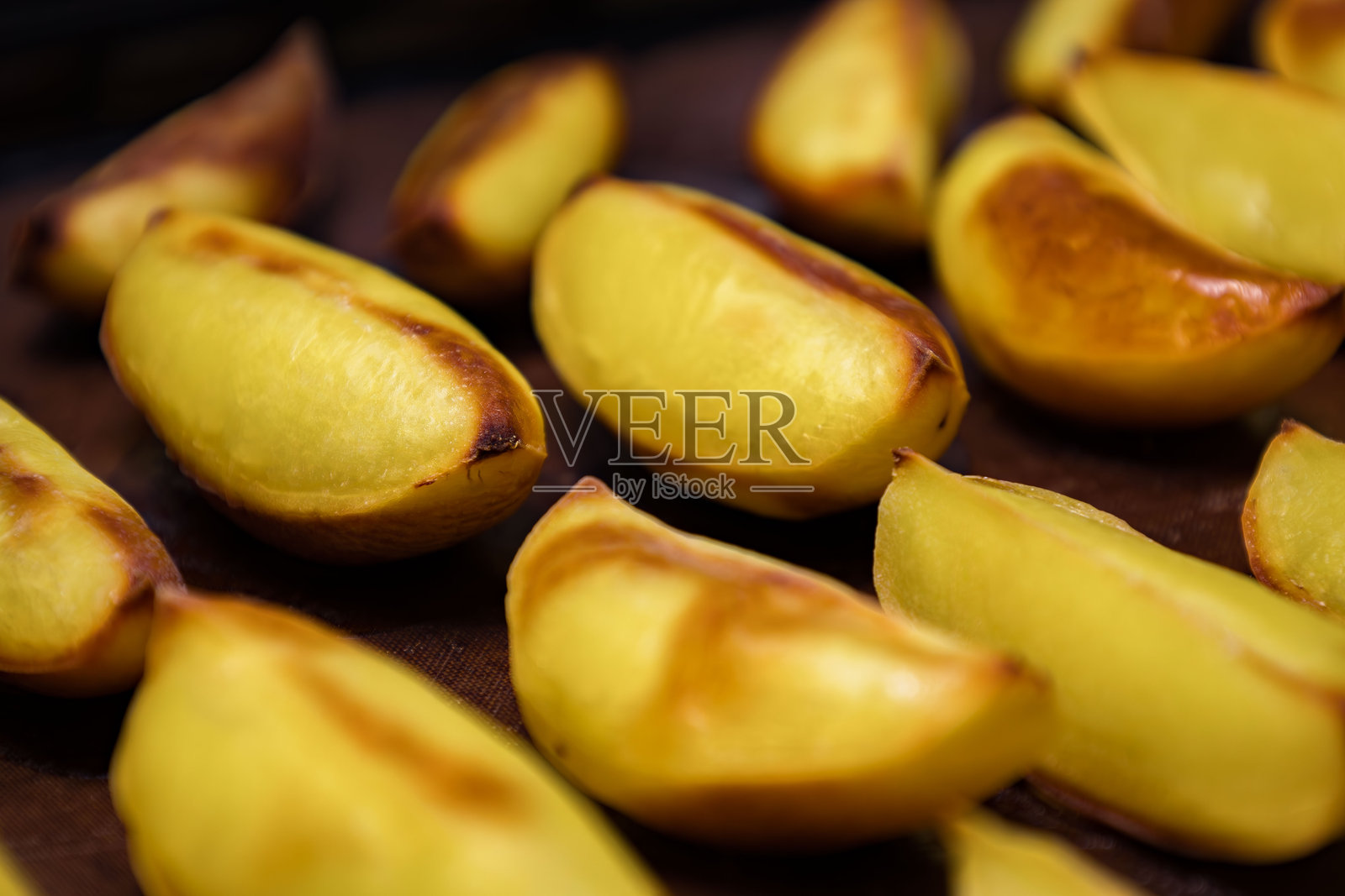 金黄烤制的马铃薯角在烤盘上整齐排列，刚出炉，非常适合作为配菜或零食享用照片摄影图片