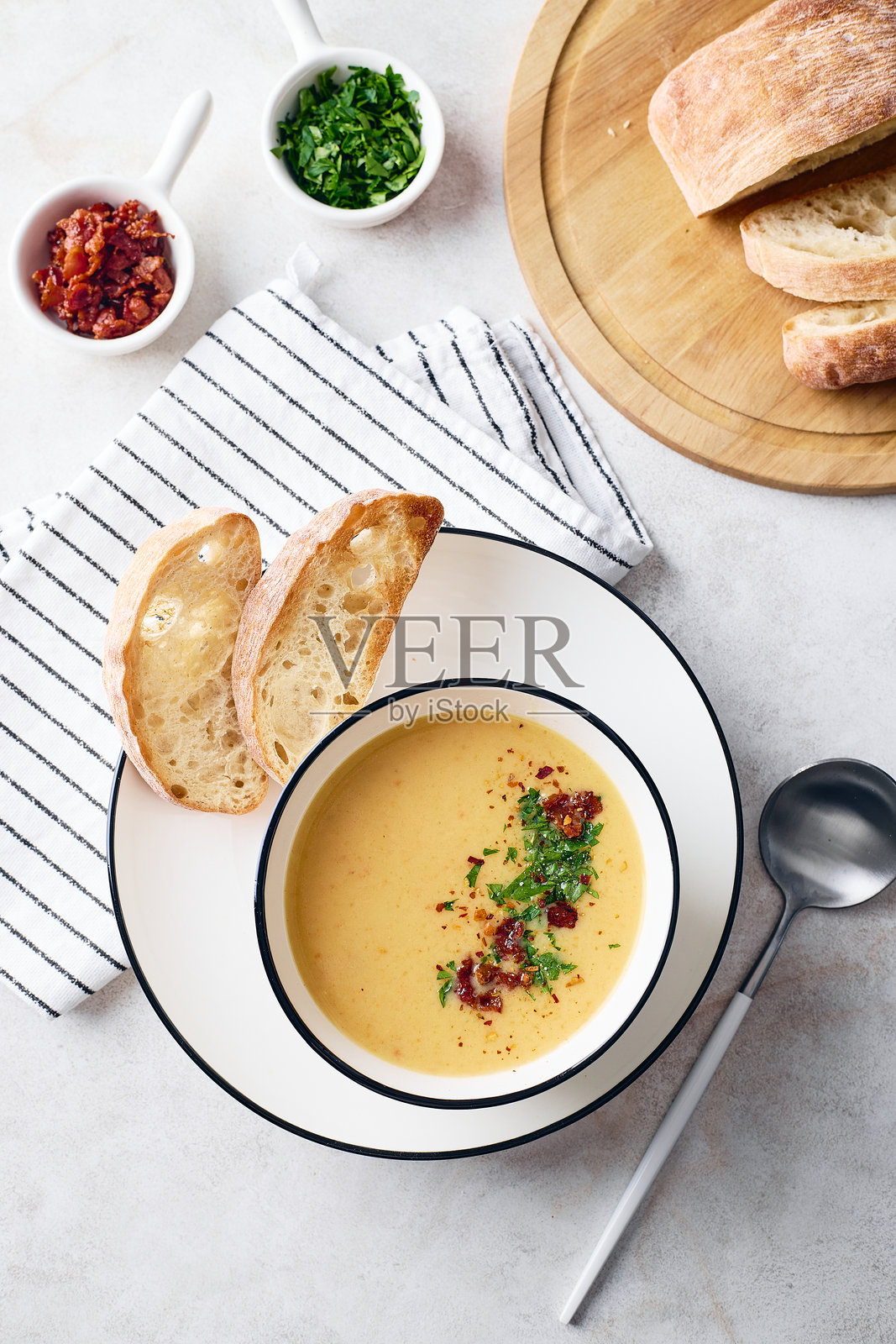 白碗装的土豆汤，配有欧芹、培根和烤面包丁。暖心餐点照片摄影图片