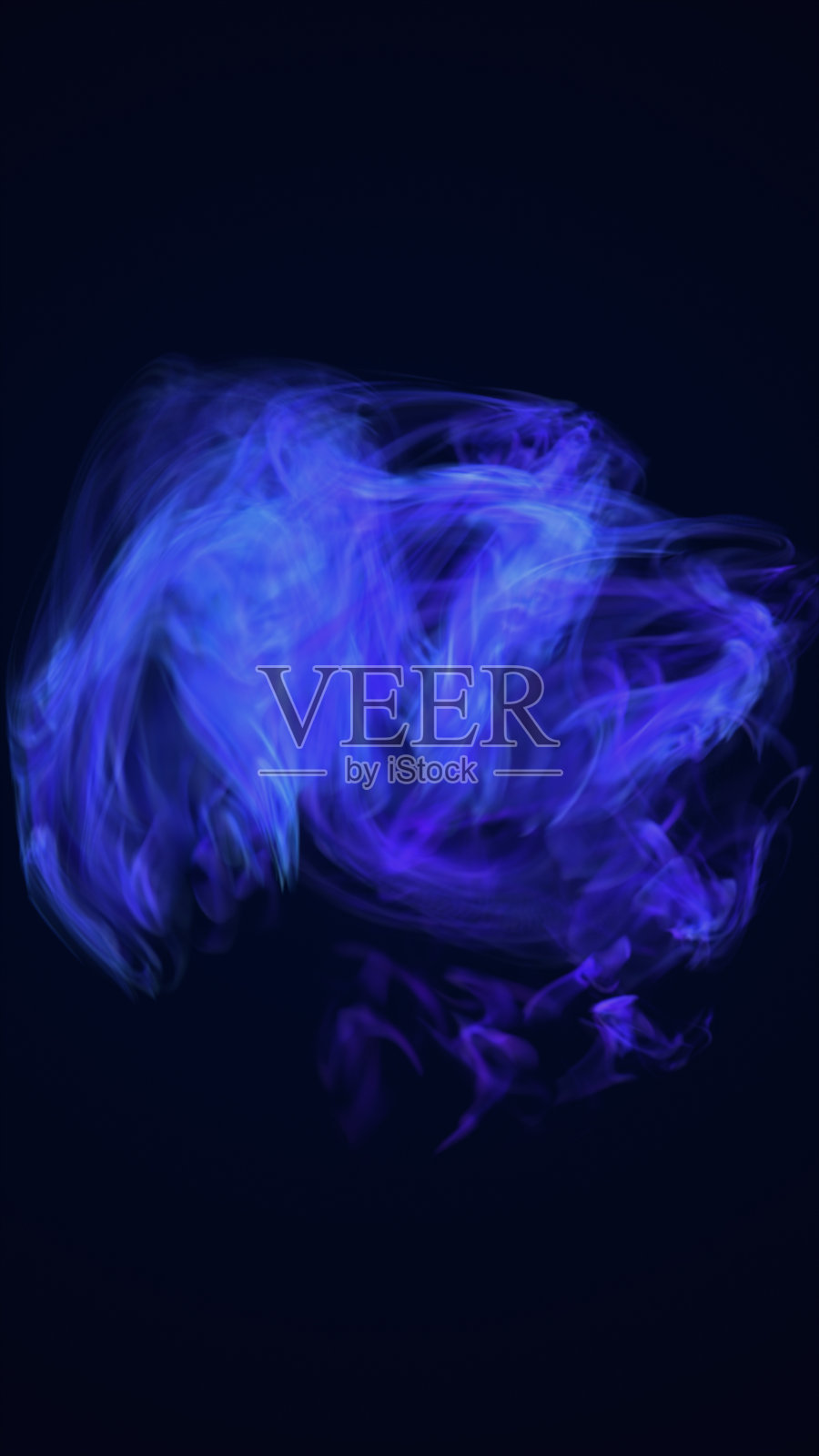 抽象的蓝色和紫色烟雾云在黑暗的背景上盘旋，唤起神秘和能量照片摄影图片