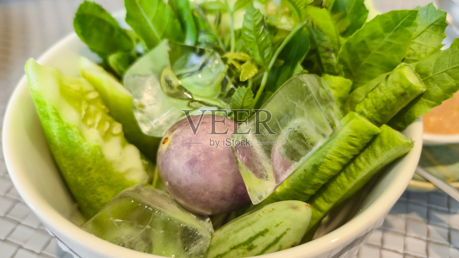 新鲜蔬菜配冰块在碗中，象征健康饮食照片摄影图片