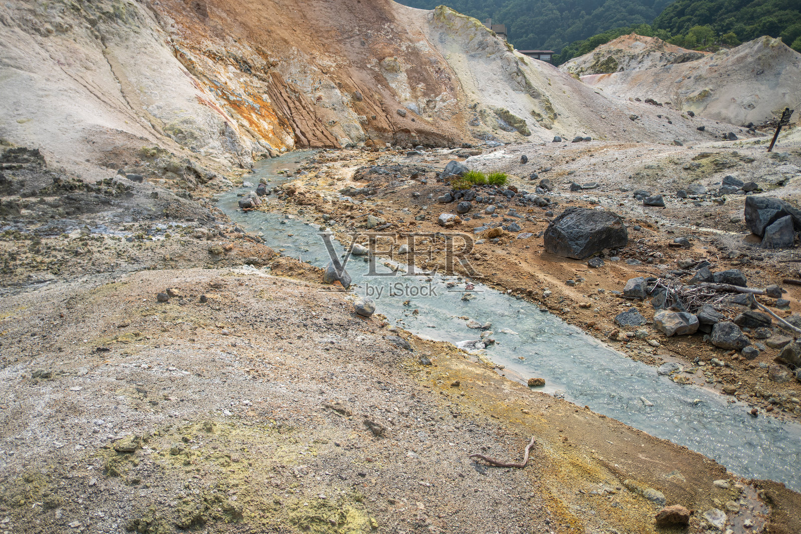 日本北海道登别地狱谷，地热温泉溪流流经岩石遍布的火山地貌照片摄影图片