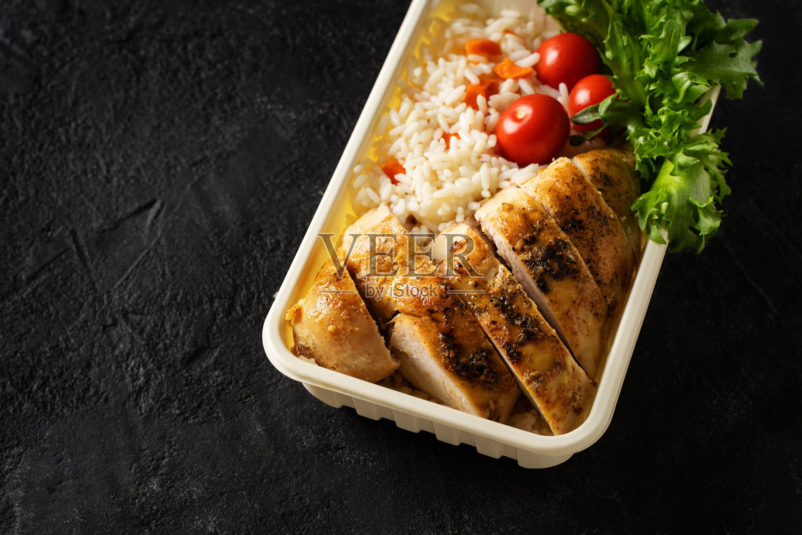 鸡肉、米饭、蔬菜、番茄、沙拉和水果的午餐盒照片摄影图片