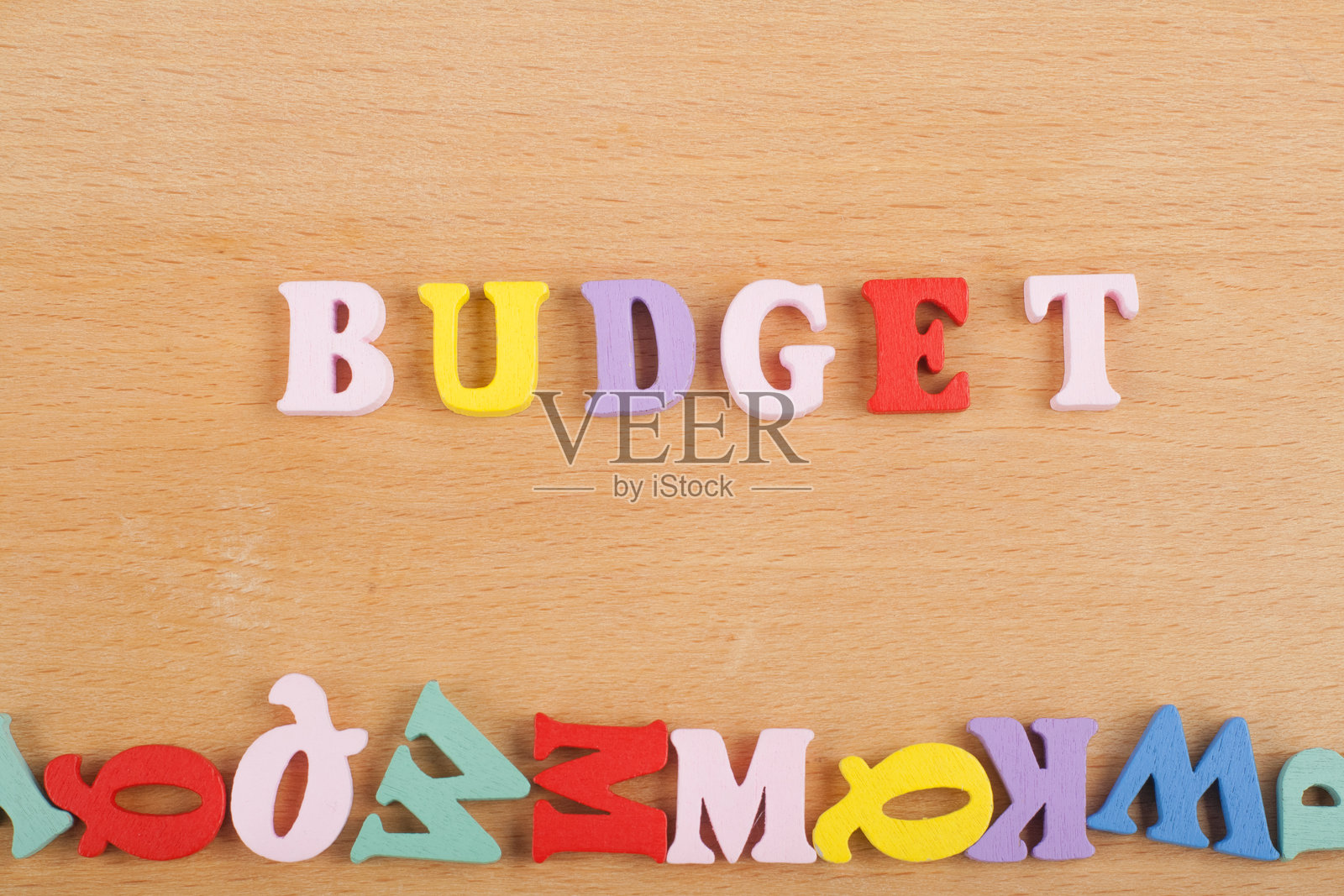 彩色字母积木组成的“BUDGET”一词，背景为木质，留有广告文字的复制空间。学习英语的概念。照片摄影图片