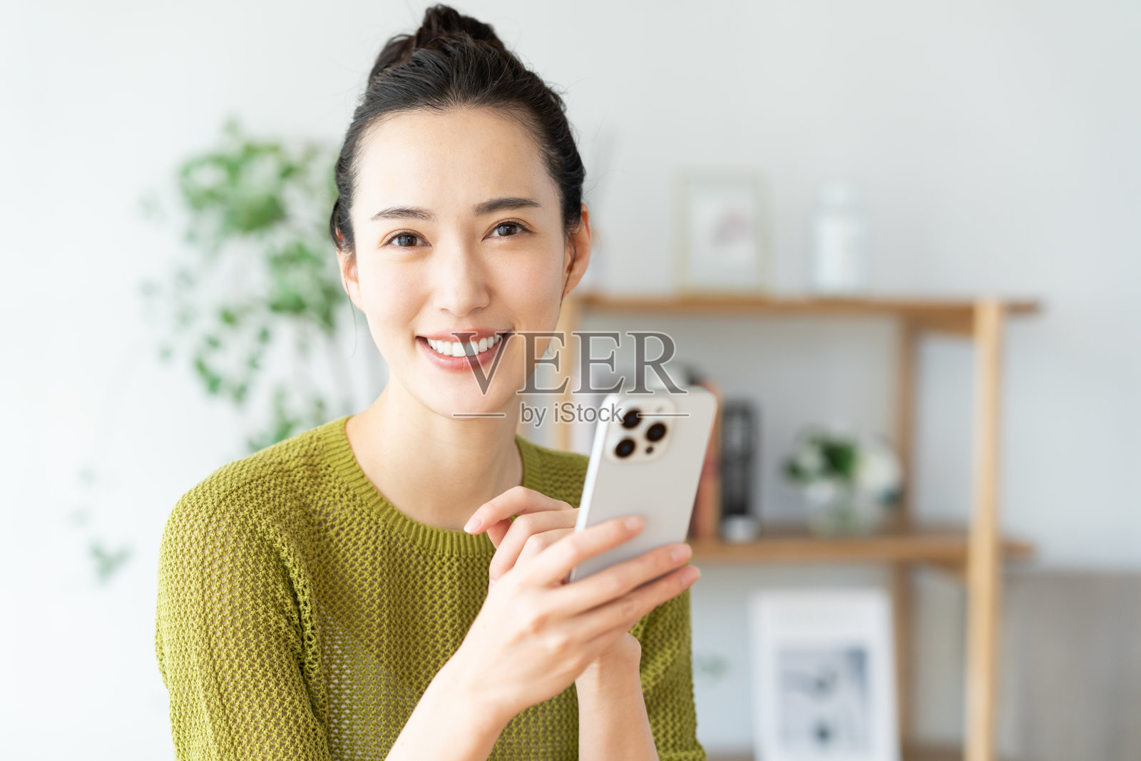 年轻女子在家中看手机照片摄影图片