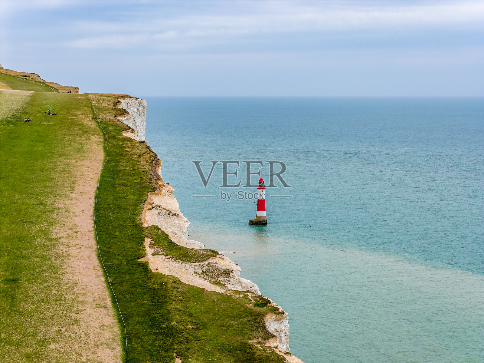 英格兰白垩悬崖下的红白灯塔照片摄影图片