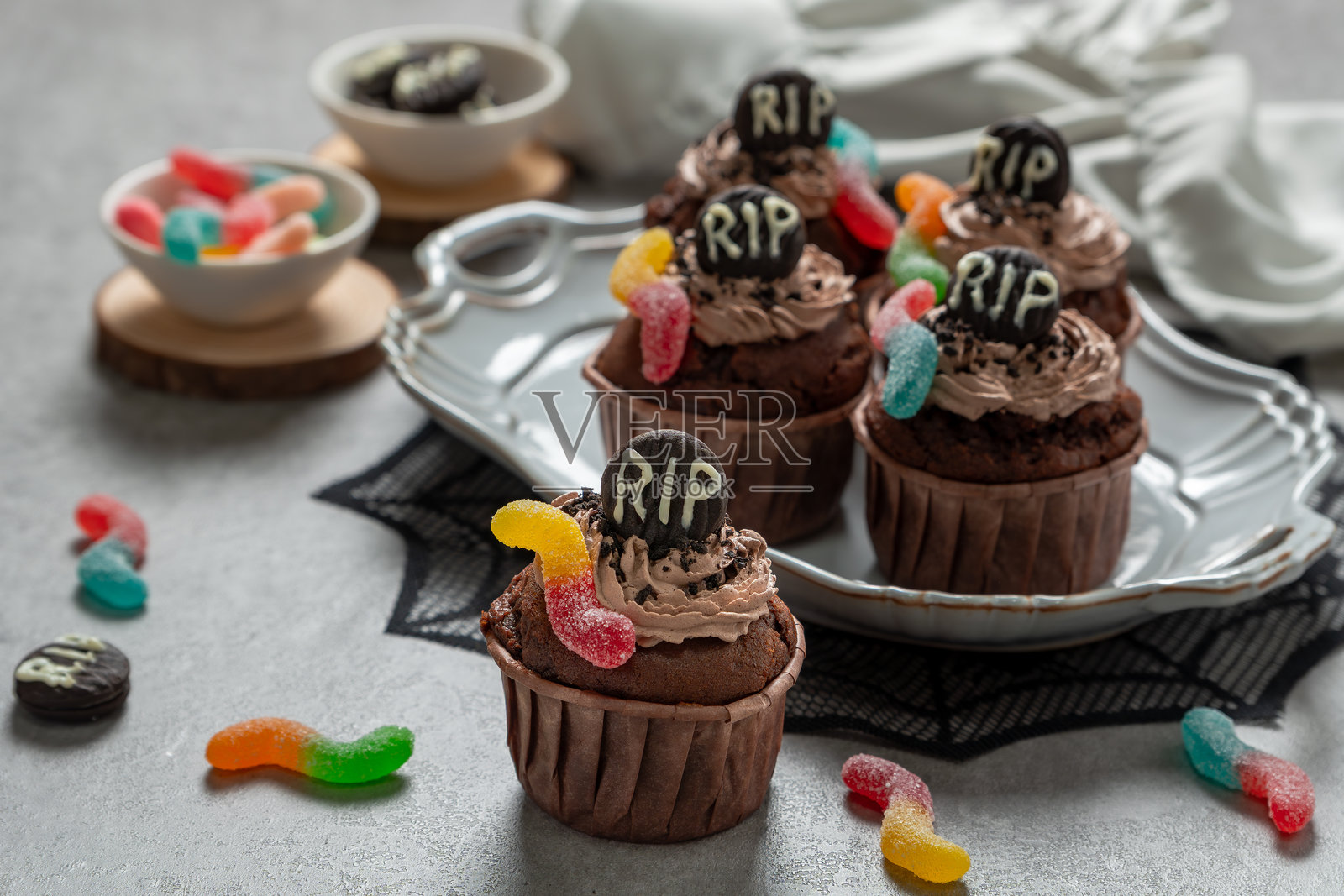 万圣节纸杯蛋糕，上面有RIP字样和橡皮软糖虫照片摄影图片