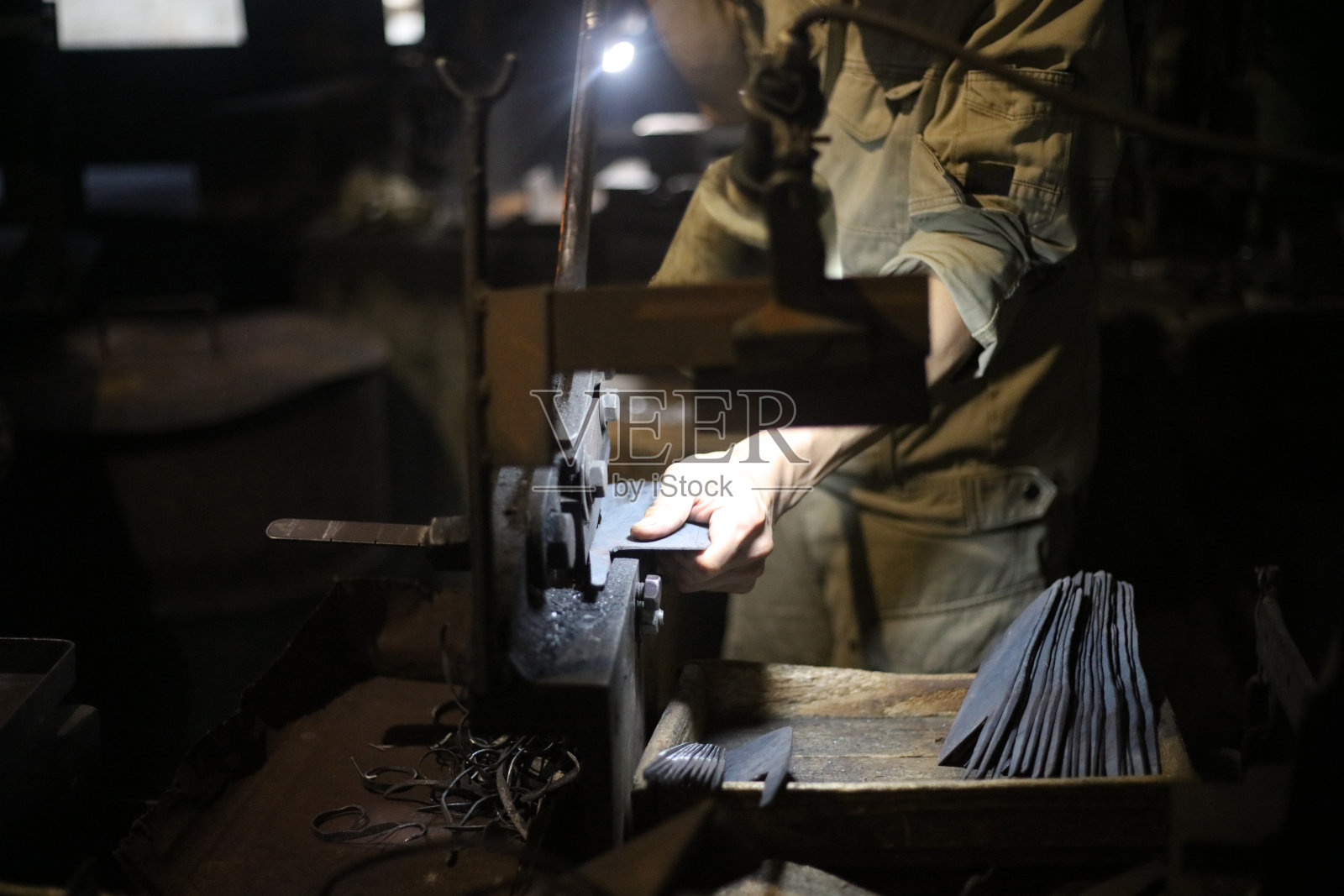 一位工匠用手工剪刀将材料剪成刀的形状照片摄影图片