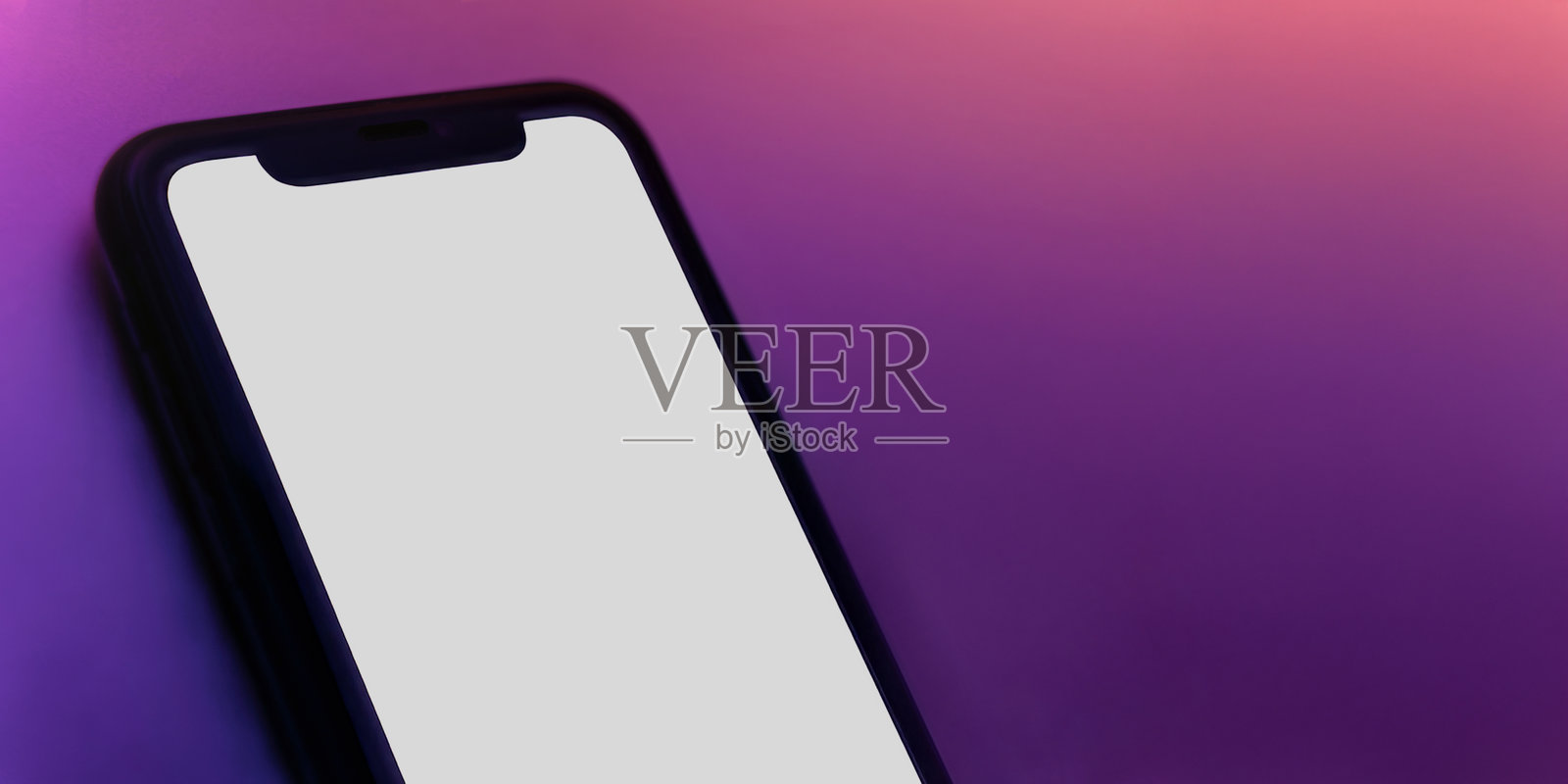 在鲜艳的霓虹色背景上，带有白色空白屏幕的智能手机模型照片摄影图片