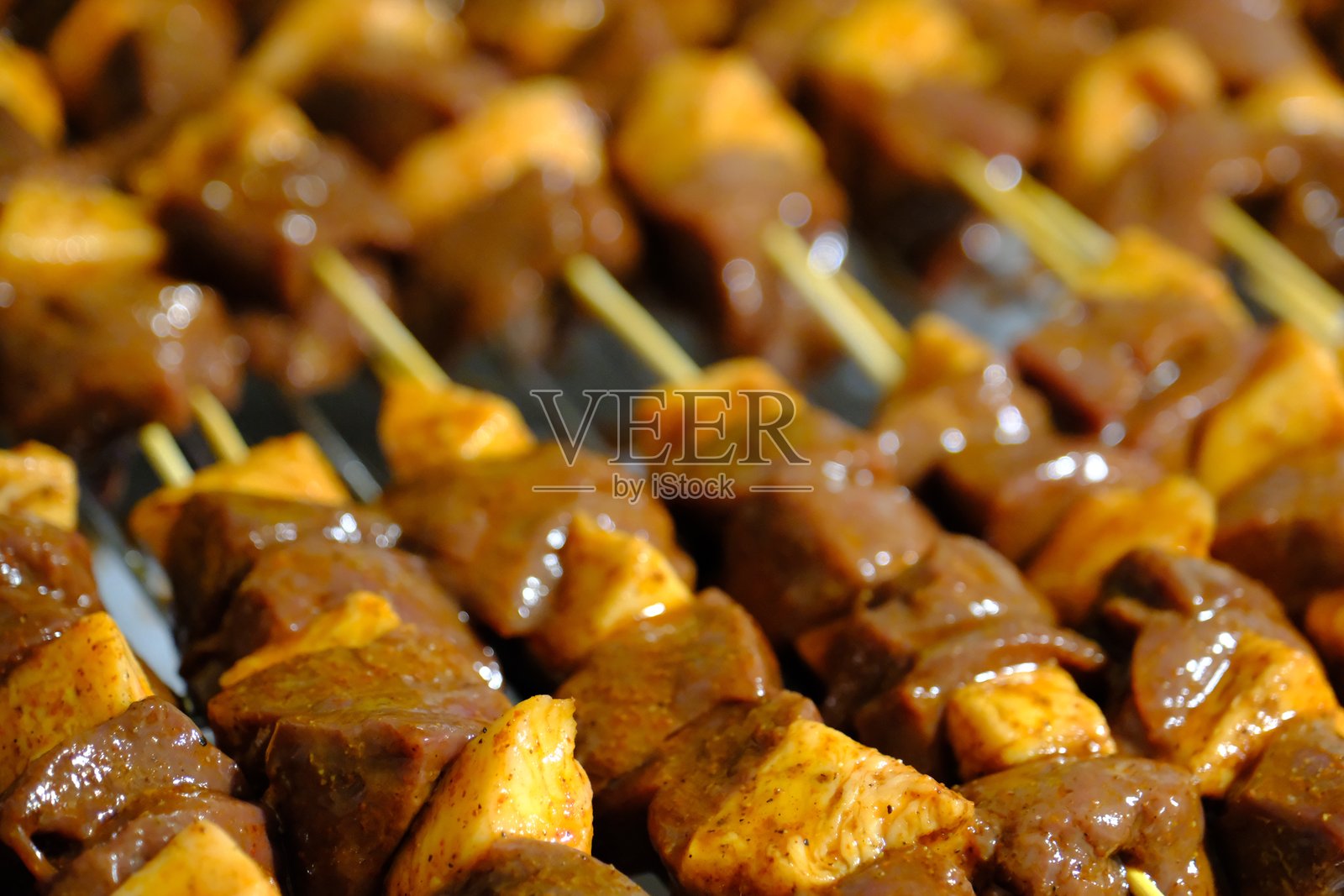 特写镜头，展示烤在竹签上的传统土耳其菜肴肝脏烤肉，配有苏马和洋葱。照片摄影图片