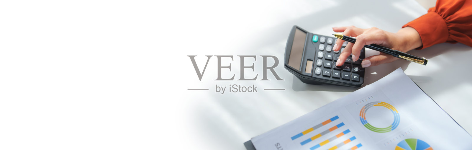 女商人正在分析财务图表并使用计算器照片摄影图片