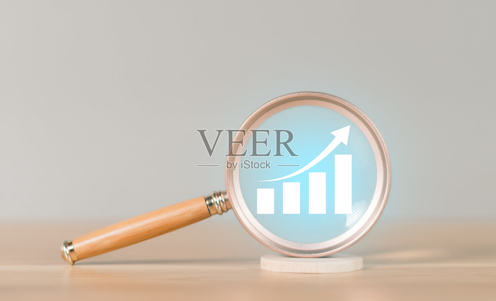 金融投资与股市金融经济财富风险计划。用放大镜查看一堆硬币和一张图表。图表显示了积极的趋势。照片摄影图片