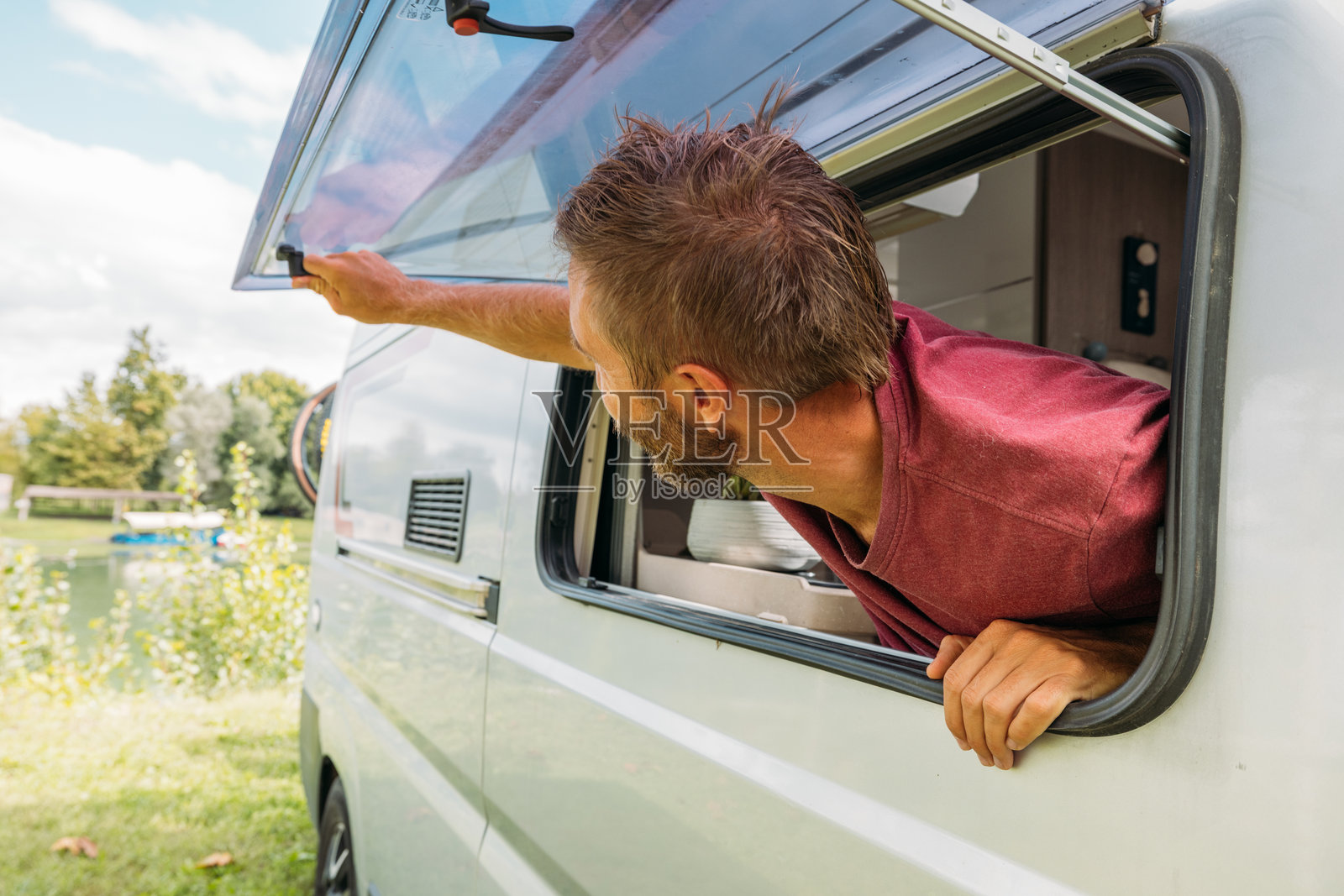 男人在户外打开露营车车窗照片摄影图片