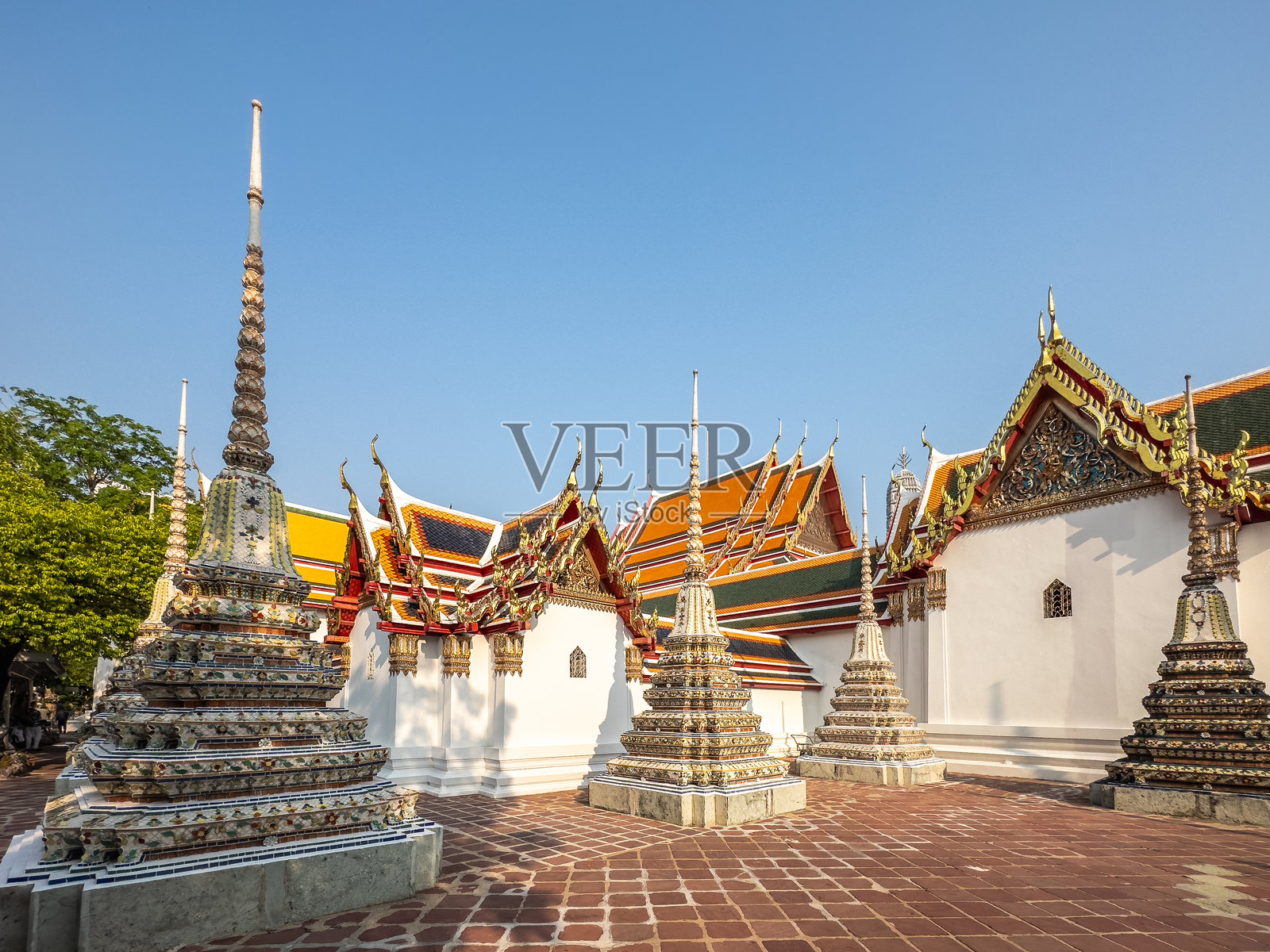 泰国曼谷宏伟的卧佛寺，在晴朗明亮的早晨，展示了其充满活力的泰国传统建筑、华丽的佛塔和金色的屋顶，是精神宁静的象征。照片摄影图片