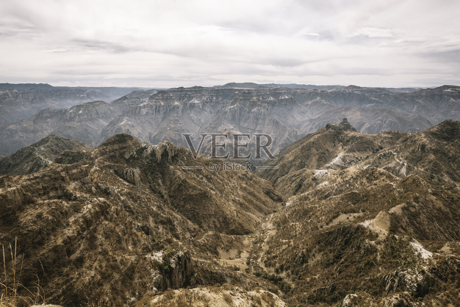 墨西哥奇瓦瓦，棕色崎岖的山脉，背景为多云的天空照片摄影图片