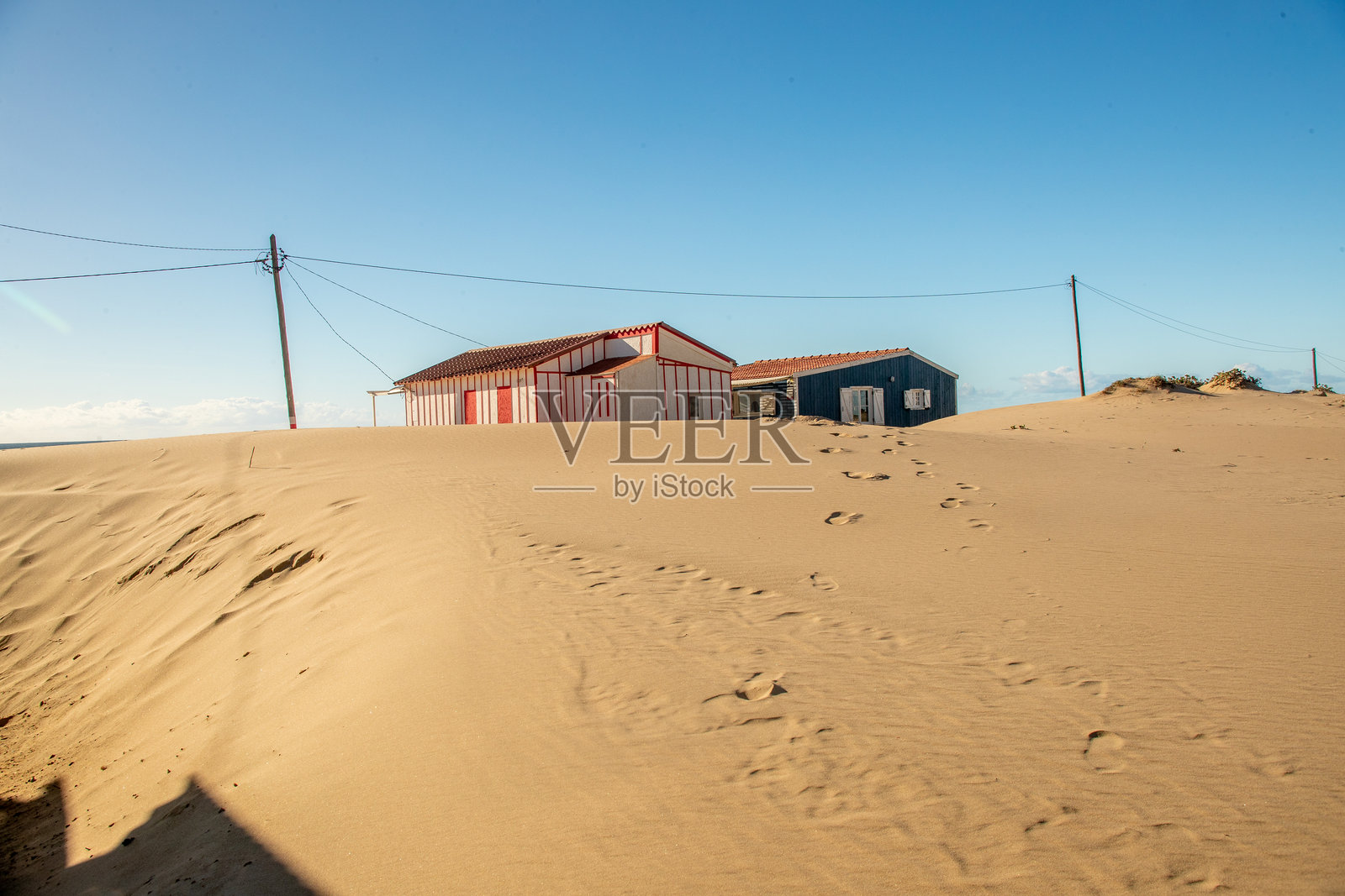 卡帕里卡，里斯本，葡萄牙。2023年12月2日。大西洋沿岸沙丘上的海滩小屋，带有红色和黄色的外墙照片摄影图片