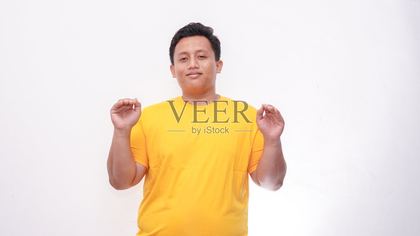 年轻的亚洲胖男人在孤立的背景上手势比划手语照片摄影图片
