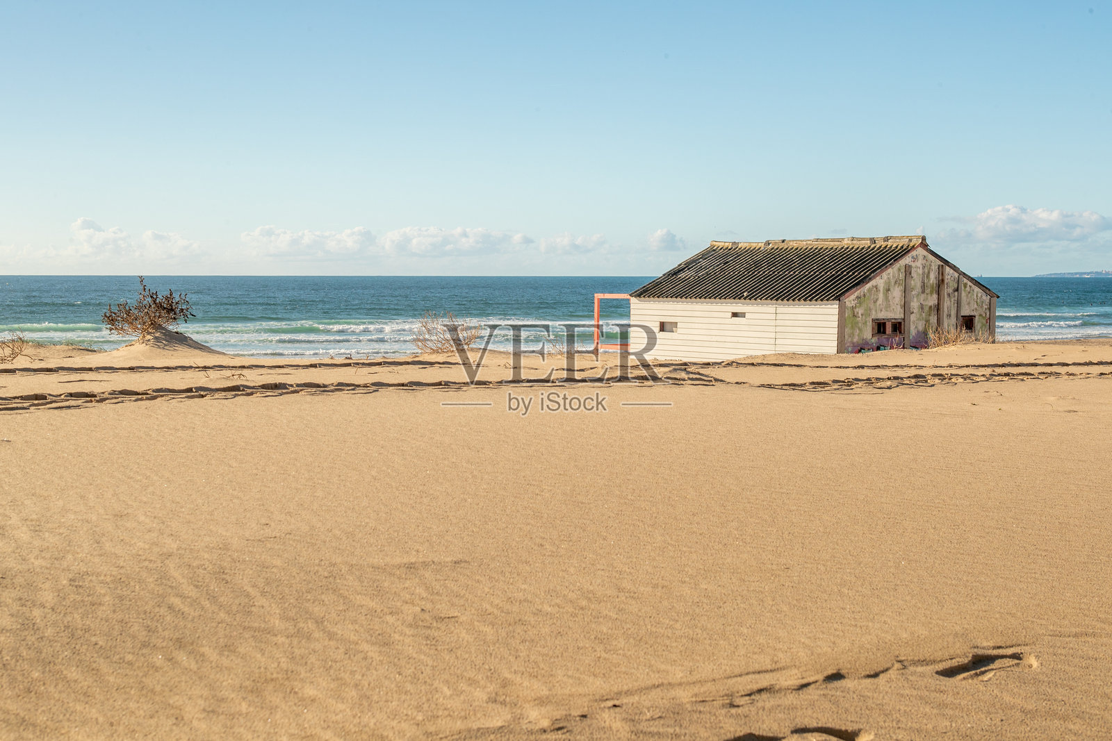 卡帕里卡，里斯本，葡萄牙。2023年12月2日。海滩小屋，拥有红色和黄色外墙，坐落在亚特兰大海岸边的沙丘上。照片摄影图片