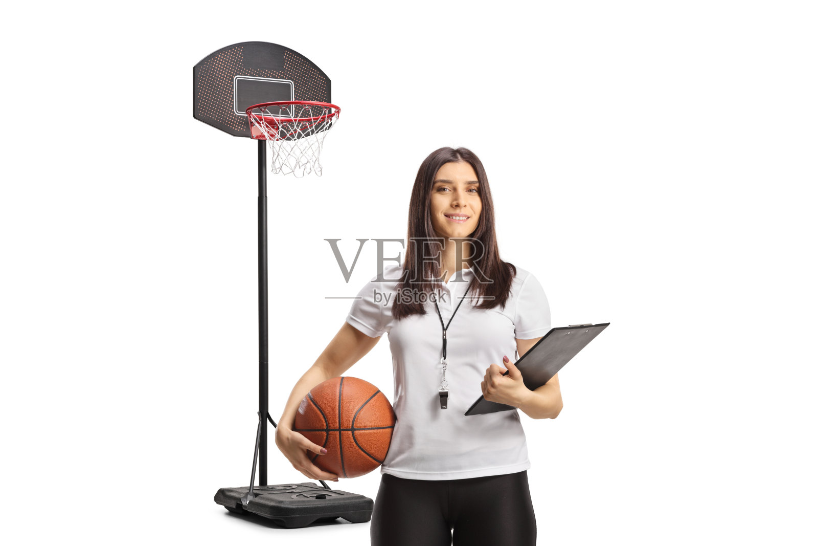 一位女性篮球教练，嘴里叼着哨子，手里拿着写字板，面带微笑照片摄影图片