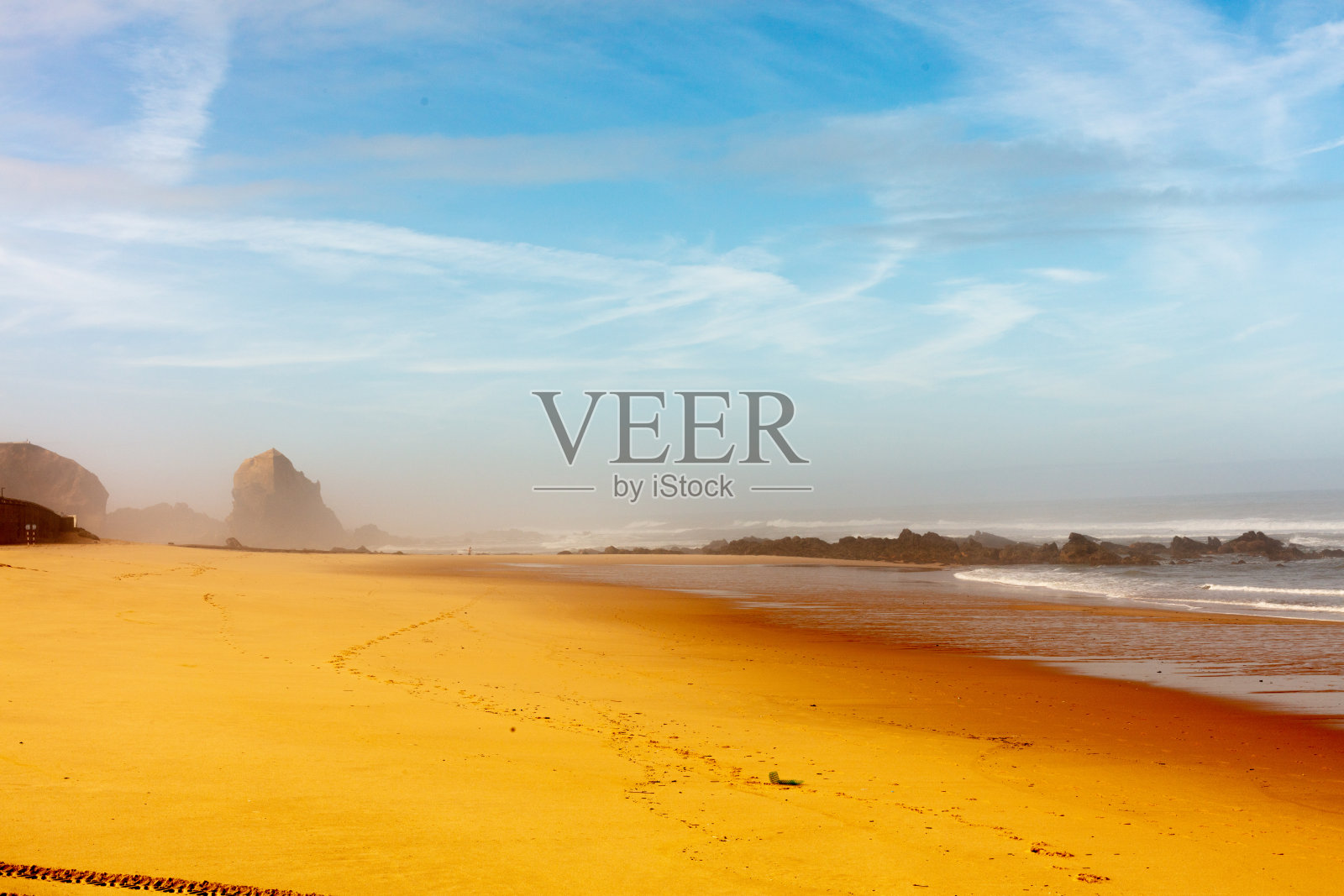 葡萄牙托雷斯韦德拉什的圣克鲁斯。2025年9月10日。在晴朗的蓝天下，宽阔的沙滩上海浪涌动。照片摄影图片